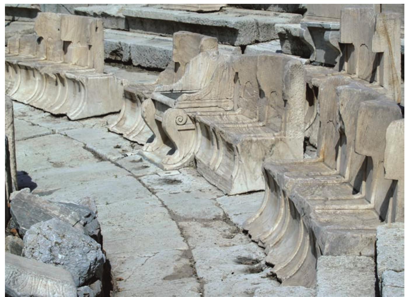 Fig. 3. Athens, Theatre of Dionysos, central prohedria beside orchestra, the Throne of the Priest of Dionysos mid-field, amidst marble Alismoi  Fig. 2. Athens, Theatre of Dionysos, central kerkis with Throne and flanking klismos-shaped seats 