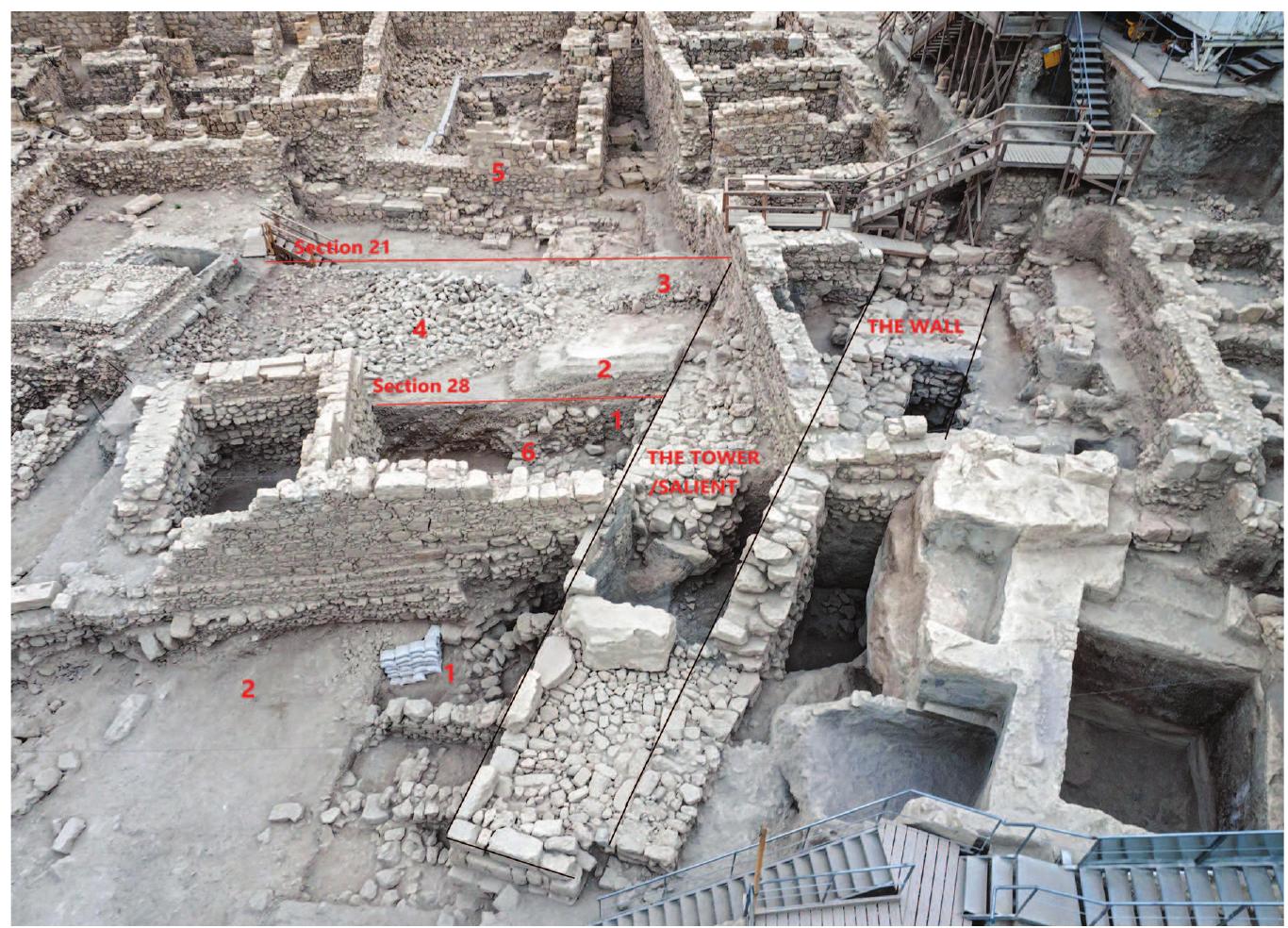 Fig. 3.1. Aerial view of Giv‘ati parking lot excavations, loo and Tchekhanovets 2016, Areas M4 and M5; fig. 2.2 in this  king north (Ben-Ami volume, Areas 10 and  50). 1. Lower layers of soil and stone (construction fills for the wall and salient)  + ashlar collapse. 2. The “gravel fill” glacis system. (Beneat  h this fill lies Area 50  Domestic Structure B; fig. 2.2 in this volume.) 3. The “pottery fill” glacis system. A great portion of these fills was also found to the north of section 21. 4. The upper-  most layer of fieldstones. 5. Building 4001 (fig. 2.2 in this vo  ume, Area 10). 6. The  location of the third- to early second-century BCE domestic structure (fig. 2.2 in this volume, Area 50, Domestic Structure A). Photograph by Skyview.  The fortification wall is wide, made of huge uncarved rocks with a core of medium to large field stones (fig. 3.1). In some parts the wall includes two lines of huge uncarved or roughly hewn rocks (maximal width 3.5 m). Where the wall lay closer to the cliff there is only one external line, since the builders probably used the deep cliff as an inner line. The central section of this wide wall was first exposed by Kenyon, and the connection between the two excavated parts could be identified. The scale of stones, double line of construction, and length secure its identi- fication as a fortification.  