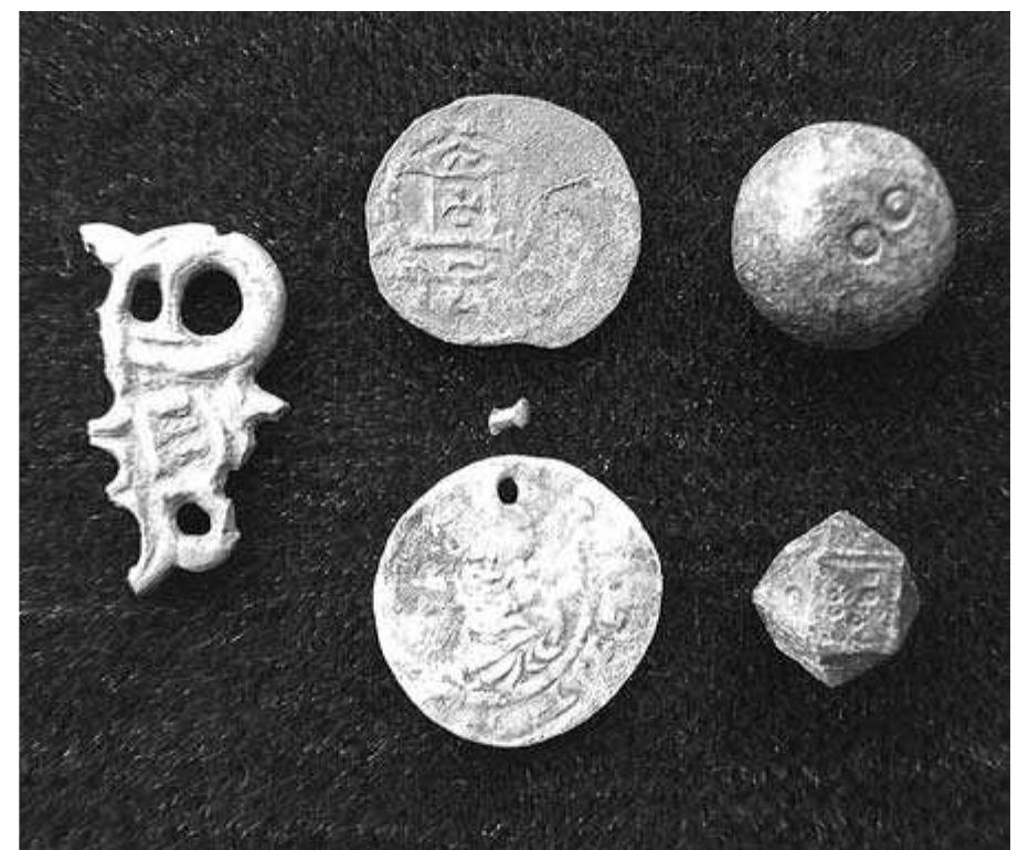 Fig. 9:4. Hov church: two German silver coins, part of a silver Urnes brooch length 25 mm, two weights; Late Viking Period, 11th century AD. Photo MR. 