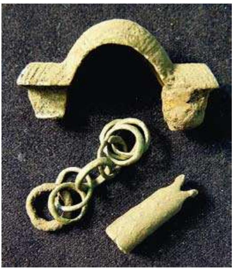 Fig. 9:35. Sverkersgarden at Alvastra in Vastra Toll- stad: small equal-armed brooch length 47 mm, fish- head sheet-metal pendant, jewellery chain; Early Ven- del Period, c. AD 570. Photo MR. 