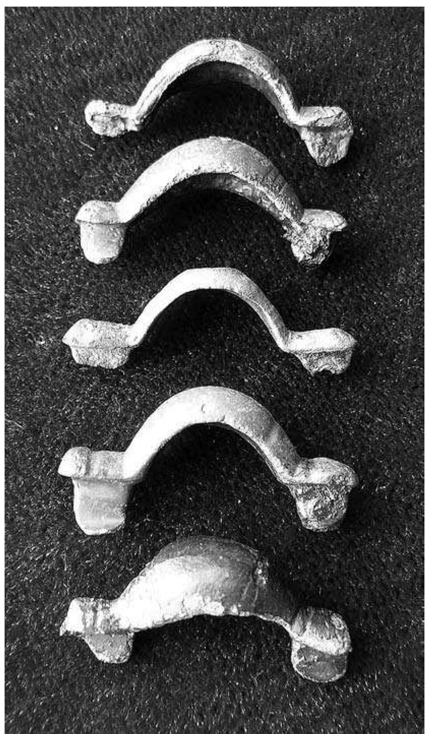 Fig. 9:13. Sattuna in Kaga: five small equal-armed brooches, Early Vendel Period, c. AD 570. Length 36-38 mm. Note that the front brooch’s pin holder and pin catch have not been completed by the craftsman. Photo MR. 
