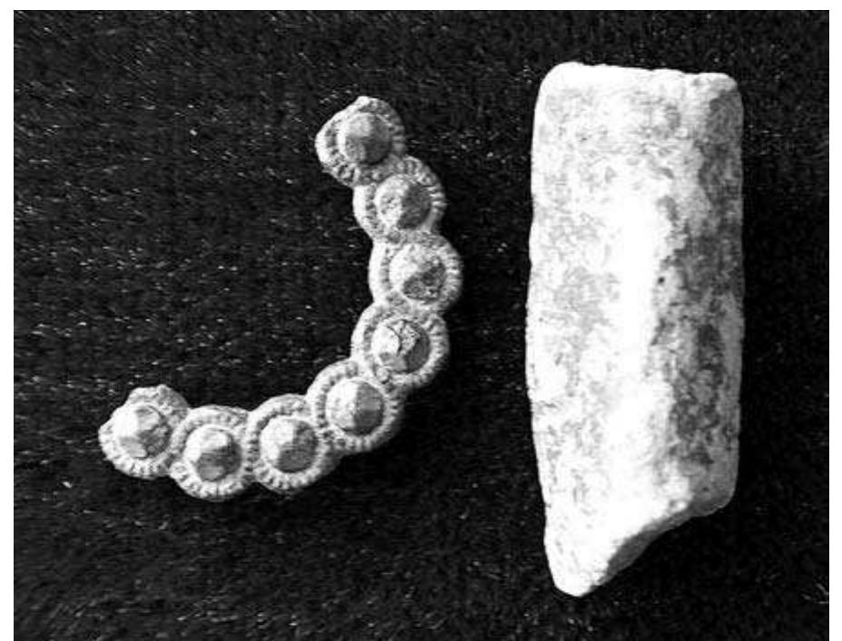 Fig. 9:19. Sattuna in Kaga: fragment of annular brooch diam. 33 mm, leg fragment from a brass tripod cooking pot; Late Medieval or Early Modern, 14th-17th centuries. Photo Mr. 