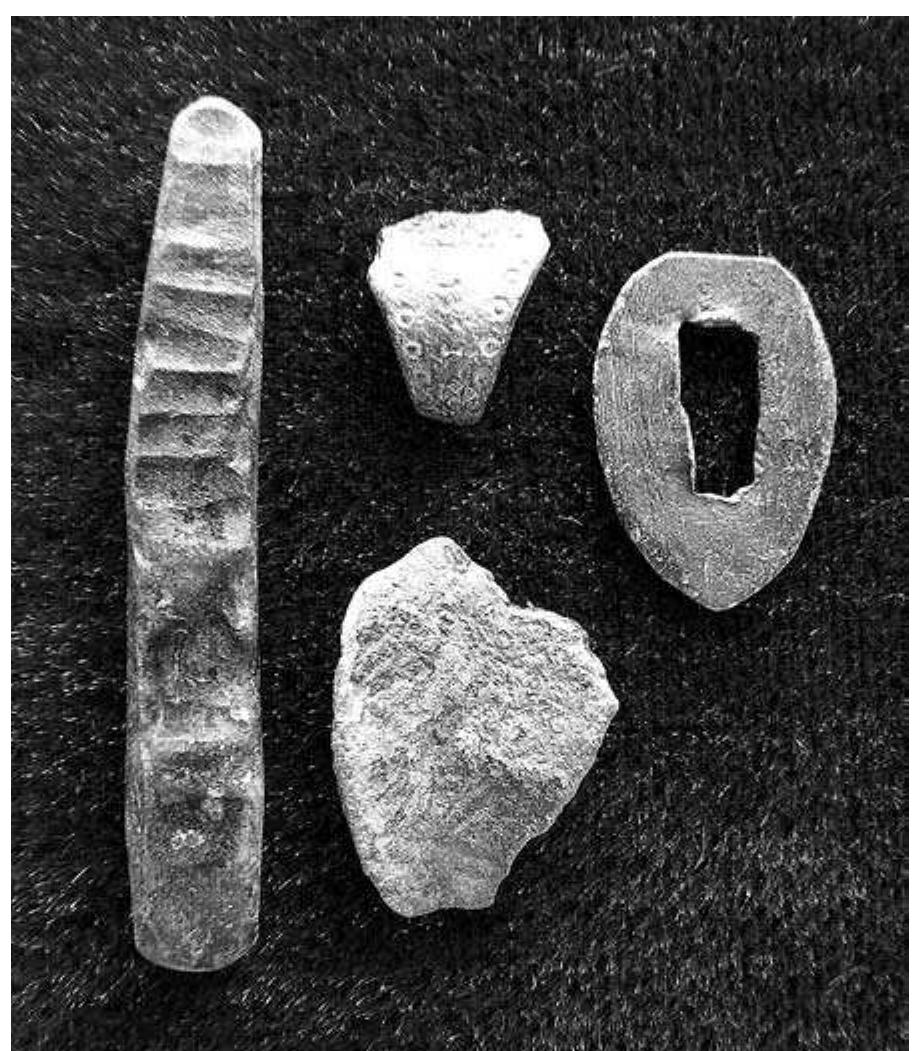Fig. 9:20. Sattuna in Kaga: cast and hammered copper-alloy bar length 54 mm, punch-decorated fragment, fragment with  cast decoration, mount for a knife handle; undated, probably Vendel Period, c. 7th century AD. Photo mr.  ten farmsteads. On a detailed arealavmatning map 