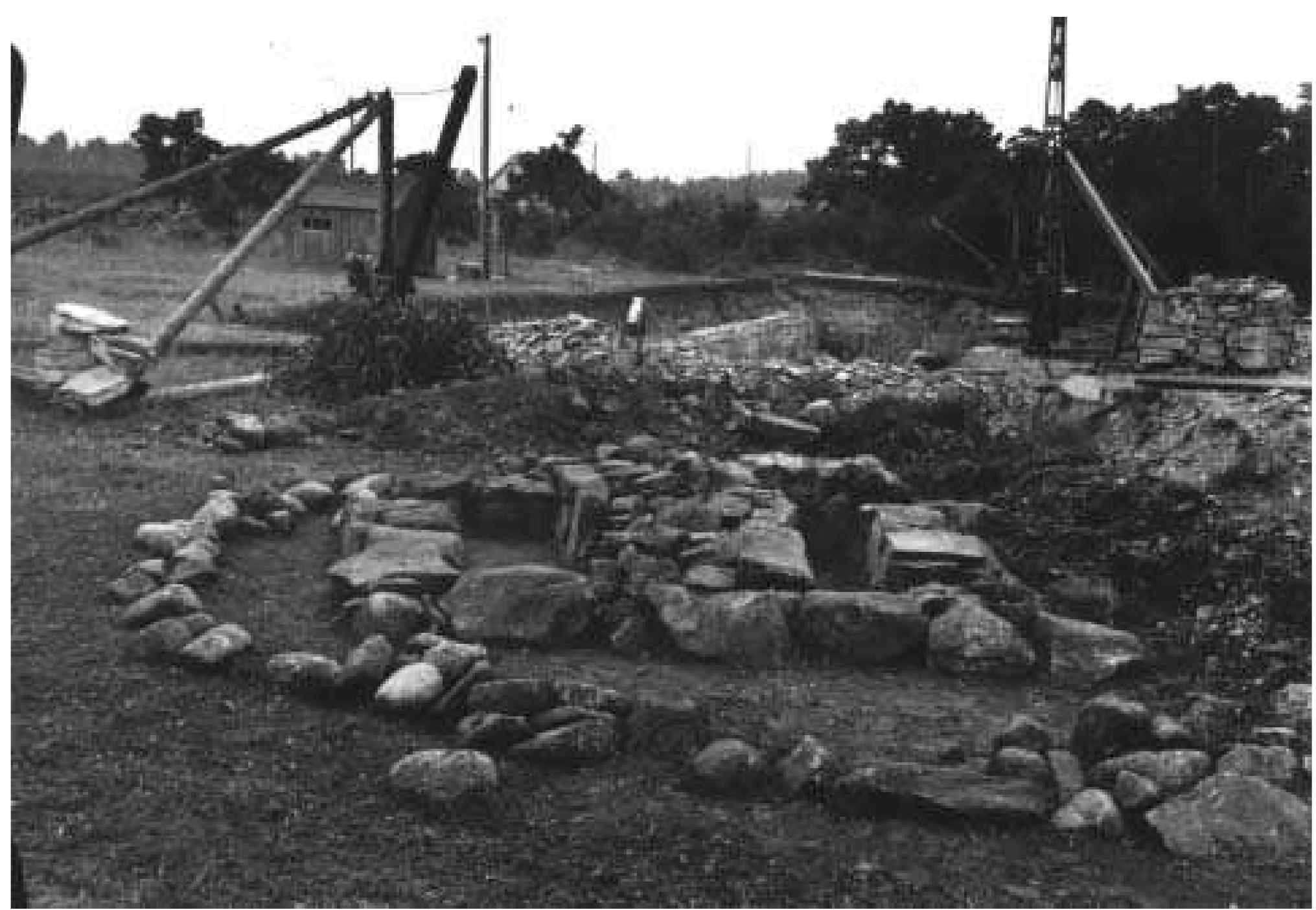 Fig. 3:7 Bhr 1947:01 in cemetery section 4 seen from the N during excavation. Beyond the grave is seen the isolated northernmost modern quarry of Uddvide and the roofs of houses located on the eastern side of the main road near the parish boundary. Photograph by Greta Arwidsson 1947 (ATA neg. 1998:42).  The excavations in Gustafsson’s garden took place over the period 22-23 October. Lacking workmen, Arwidsson confined her excavations to an area north of the house where  Olof V. Ohlsson died in the summer of 1940. The War did  not touch Gotland, although it seems to have prevented ex- 