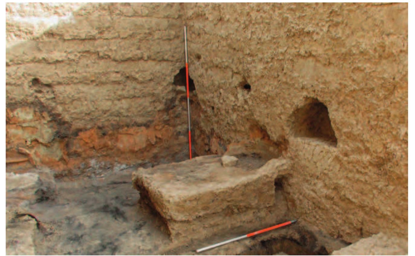 Fig. 26. The north-east corner of Room | showing the altar, a niche in the corner behind the ranging rod, a niche in the east wall and two possible ventilation holes at the same height as the niches on the north and east walls. 
