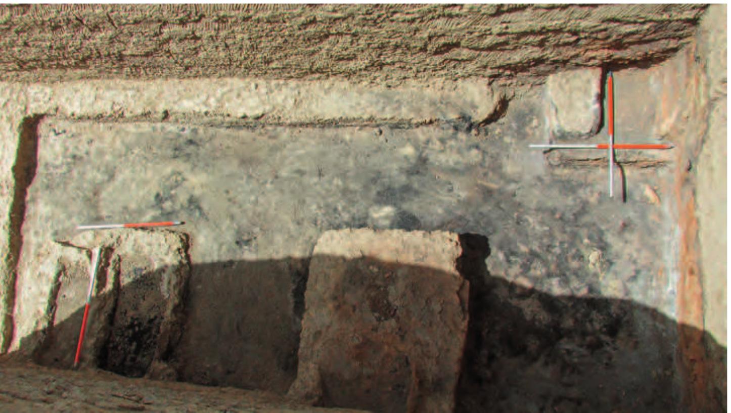 Fig. 29. Vertical view of the north end of Room | showing the altar against the east wall and fire installations in the north-west corner and against the east wall to the south of the altar.  a a I i  A further fire installation was constructed in the north-west corner of Room | (Figs. 29-31). This consisted of a rectangular mud-brick platform measuring (85 cm wide (N-S), 65 cm deep (E-W), and 27 cm high. It was divided into two parts. To the north in the corner was a fireplace level with the top of the platform (about 55 cm long (E-W), 35 cm wide (N-S), and 9 cm deep). The oval shape of this fireplace was formed by mud plaster. To  the south raised up about 9 cm above the to  p of the platform was a U-shaped  fireplace surrounded on three sides by a narrow ledge about 4-6 cm wide. The northern fireplace may have been re  with the top of fireplaces were a grey colour. T  he southern fireplace. All  he north wall behind the p  placed by a later fireplace level surfaces of the platform and the  burnt. The west wall behind this platform was also burnt to  atform and extending to the east  the north wall was burnt grey and red in a semi-circular shape edged in black from the smoke of the fire (Fig. 32). Further to the east the lower part  of the north wal  was also burnt to a red colour again with a black edge. 