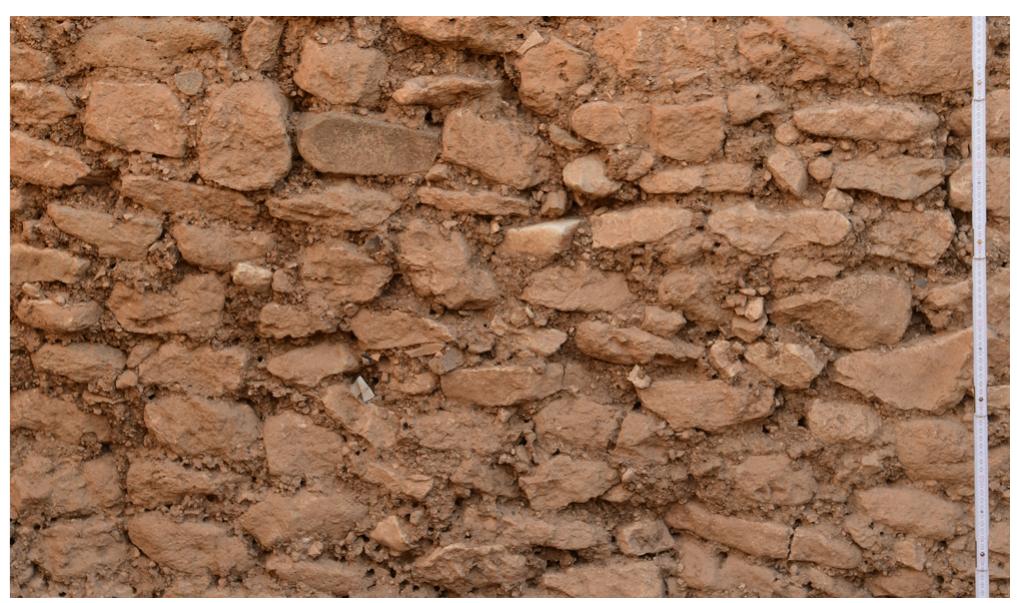 Figure 15: Reused materials in the mortar: bone, lithics, small stones, charcoal, and lime. Northern wall Loc. L9-80-23 of Room 16, area L9-80 (detail) (photo: Moritz Kinzel/DAI). 