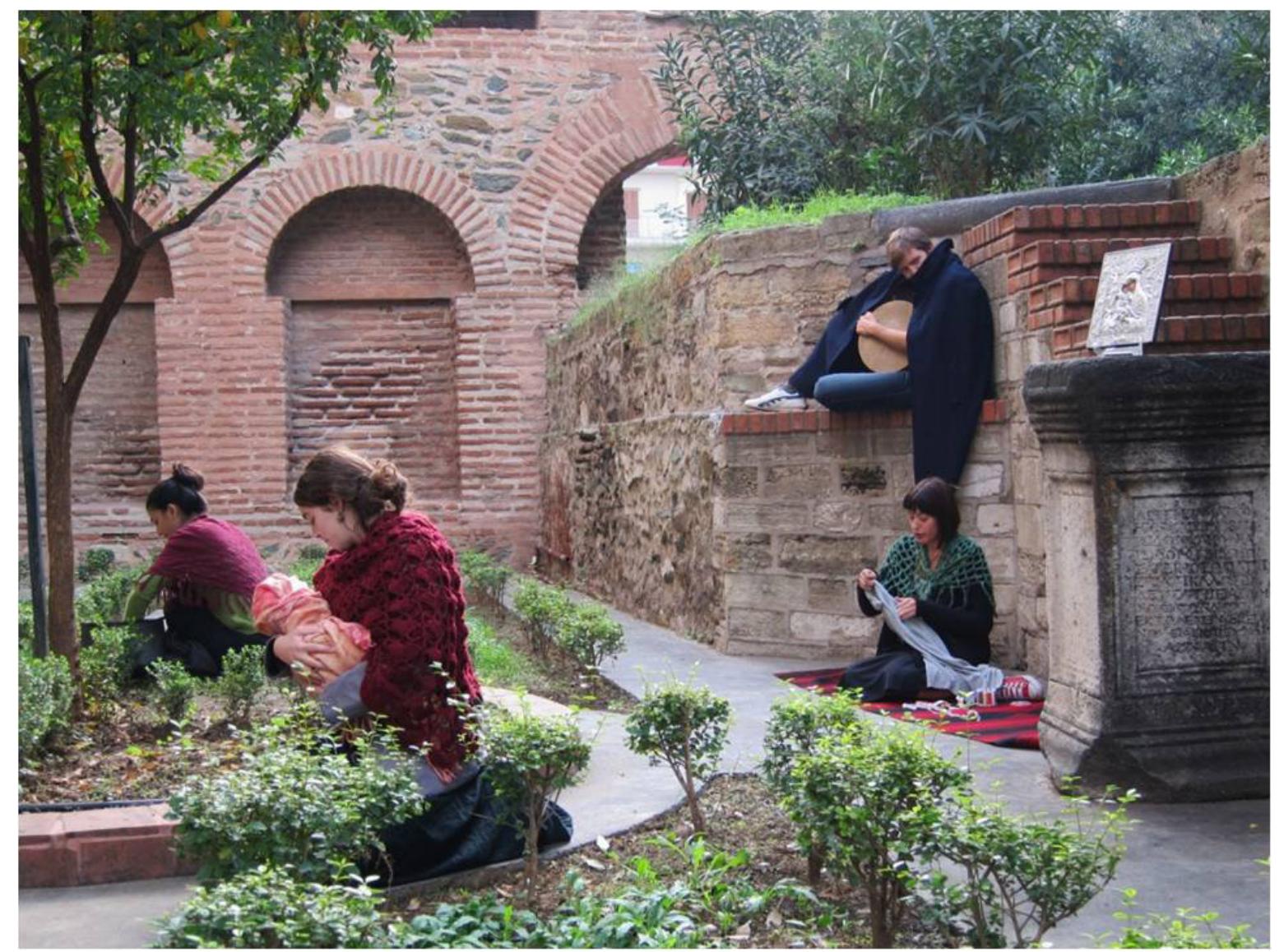 The fifth performance took place at the courtyard of the Byzantine church of Panagie Acheiropoietos where Greek refugees had settled in 1922 after the Asia Minor Holocaust Panagia Acheiropoietos was the only church which hosted refugees during that time and sx it was the chosen location to highlight the refugee’s status at the beginning of the century. / short introduction referring to the church’s history preceded the performance. Following, the audience watched a scene of the everyday life of the refugees during their stay in the churct performed at the church’s courtyard. Interpreters in the refugees’ roles expressed a feeling o nostalgia for the life they were forced to abandon and they commented on the problems the\ encountered during their stay in the city: racism, extremely low-wages, homelessness, poverty and child labor. The scene ended with a song, sung by the refugees. The performance adoptec a traditional form without any interaction with the audience and made use of costumes, object: and live music, played by the interpreters-in-role.  After the performance, students were led to the church’s entrance where the storyteller initiated a ‘questions and answers’ session around the refugees’ contribution to the city, its acknowledgment by the citizens, and the preconceptions that surround refugees and immigrants both in the past and the present. It is worth mentioning that the 1922 Asia Minor refugees are nowadays  recognized for the multiple ways they enriched Greek heritage; a very different approach to the one adopted when they first arrived. 