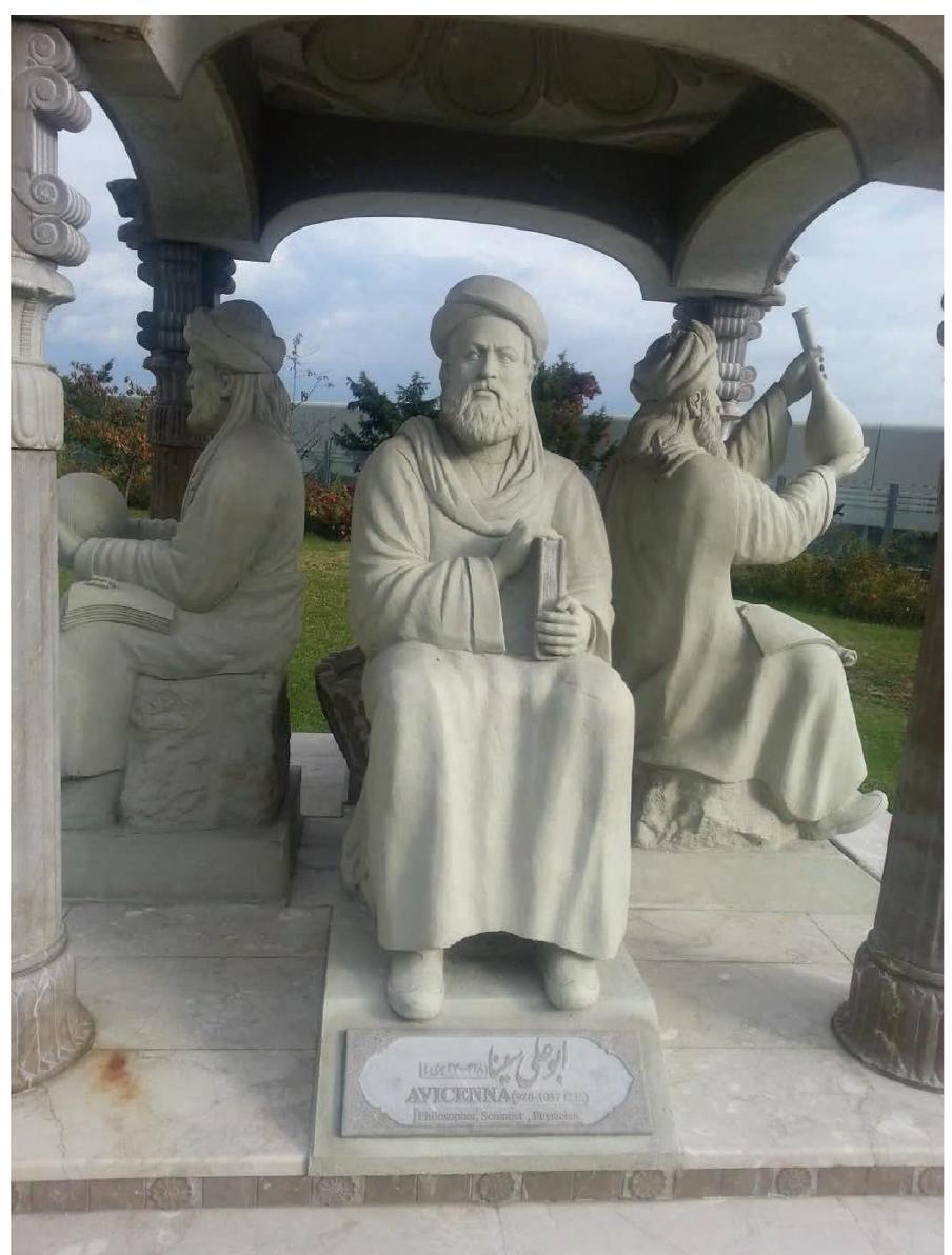 Ficure 6: Ibn Sina, aka Avicenna (middle) as part of the scholars Pavilion or scholars Chartagi. The monument is located outside the Unit ed Nations Ooffice at Vienna, Austria. Credit: Yamaha5, CC BY-SA 3.0 <https://creativecommons.org/licenses/by-sa/3.0>, via Wikimedia com mons. Available from https://upload.wikimedia.org/wikipedia/common s/f/f3/Persian_Scholar_pavilion_in_Viena_UN_%28Avicenna%29.jpg. 