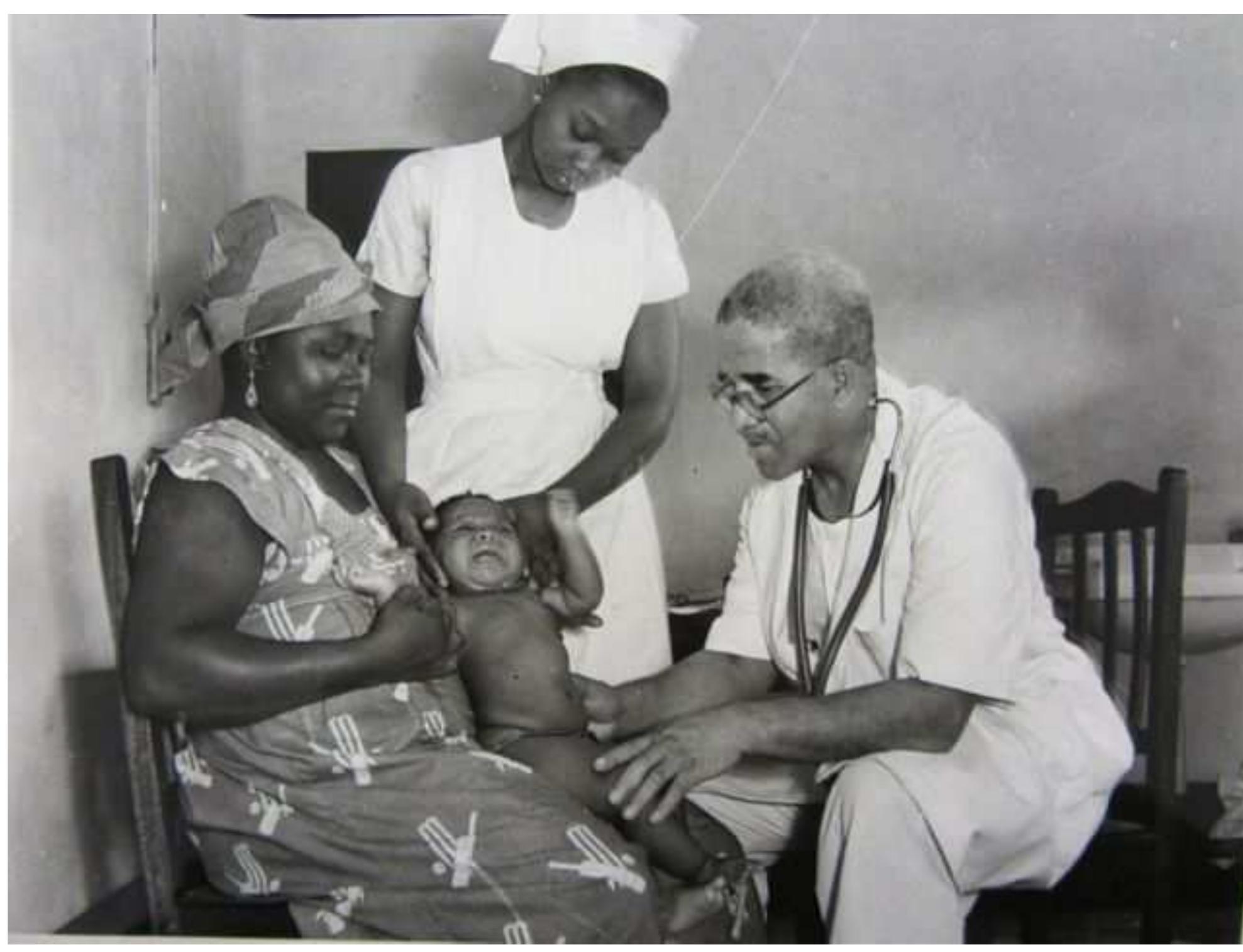 In this photograph Dr. M.C.F. Easmon appears to be examining an infant. The 