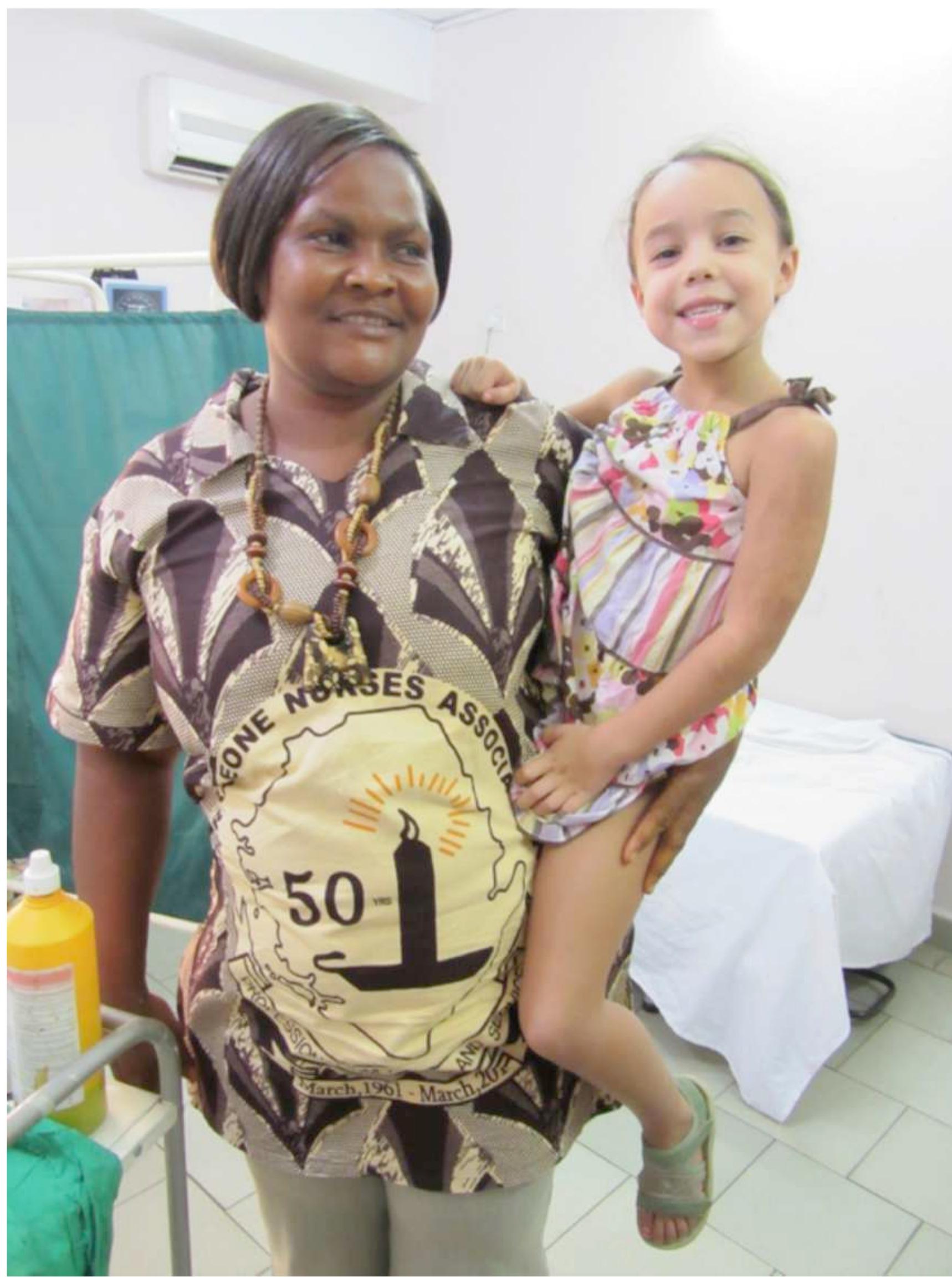 Figure 18: A nurse in Freetown wearing a uniform shirt made of fabric marking the 50th anniversary of the Sierra Leone Nurses Association. Commemorative fabrics are used throughout sub-Saharan Africa to visually document important people and events. This cloth features the emblem of the Association: Florence Nightingale's lamp. The cloth may only be purchased from the Sierra Leone Nurse’s Association. Photo by Tara Dosumu Diener, 2012 