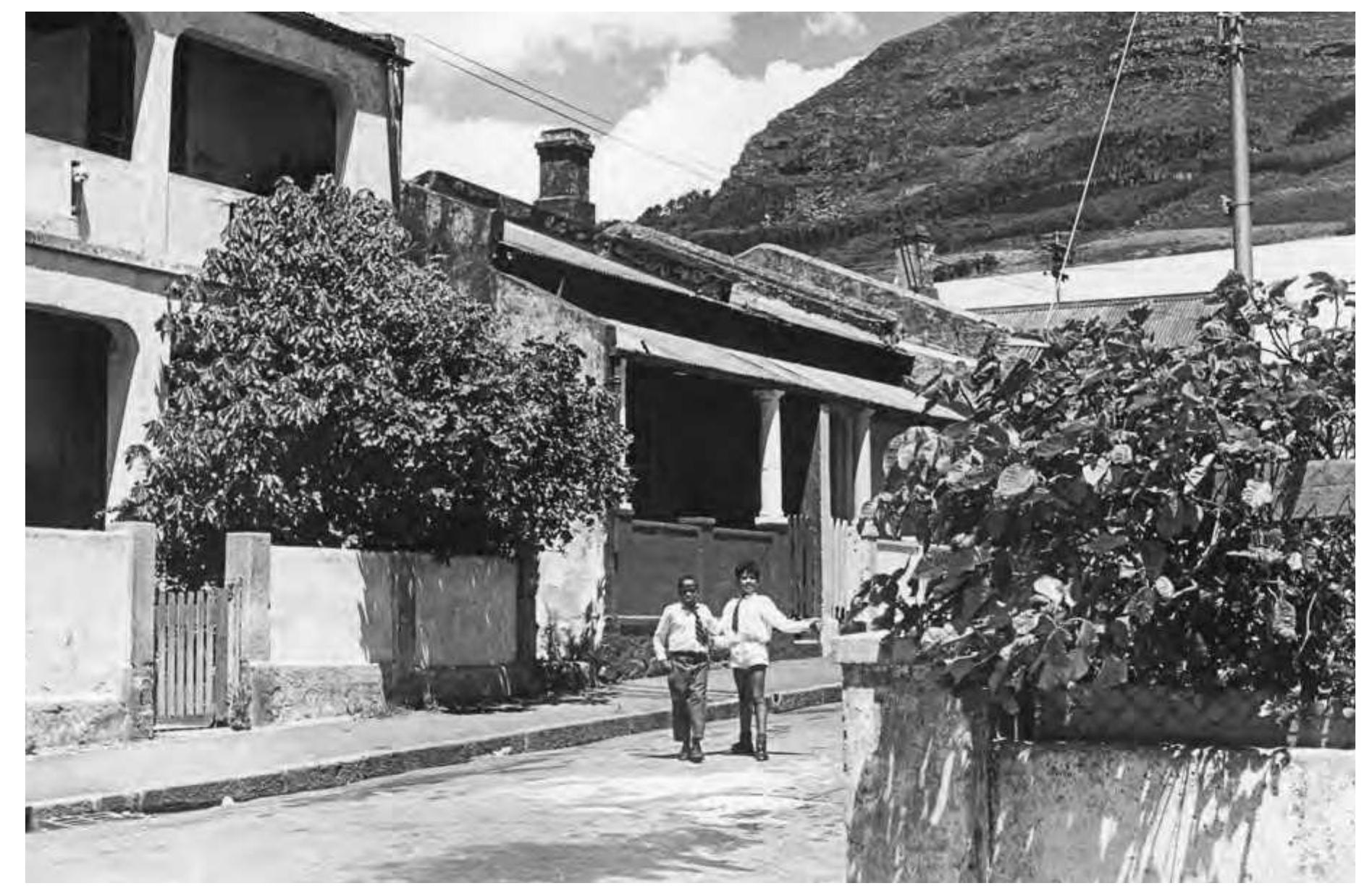 This relatively unstructured relationship between citizens and the nearby nature of the mountain changed with the implementation of the Group Areas Act, in which modernist planning tenets and racial anxieties combined to transform the previously heterogeneous sociospatial patterning of the city.” Historically, non-European popu- lations from areas deemed to be unhealthy had been sporadically removed to outlying areas,” but it was not until the 1960s that built and open space, as well as transpor- tation throughout the city, became fully segregated. Nearly two hundred thousand non-European Capetonians who lived near the mountain—mostly “Coloured” and comprising one-fifth of the city’s population at the time—were forcibly resettled in new economic housing on the Cape Flats (Figure 14.18). Although District Six is the most infamous example of this brutal resettlement, many other neighborhoods were affected as well.?? Table Mountain was transformed from being more or less accessible shared landscape into an index of apartheid; the city center and suburbs at the base of the moun- tain increasingly became spaces in which only white residents had unrestricted access to the sea and the mountain.  ee eee ee Horstley Street, District Six, Cape Town, 1960s, before the removal of its residents to the Cape Flats. 