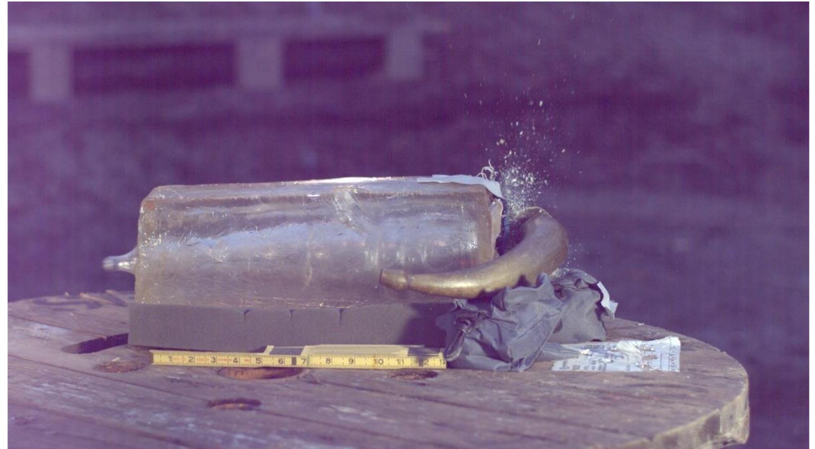 Figure 43. The ball exiting the ballistic gelatin block and powder horn 2 starting to shatter. 