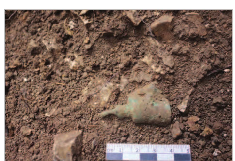 Fig. 18- Area 2/3: bronze bell found close to the wall in the tomb.  discovered inside the tomb. A comparative study of funerary practices for this period in the wider region will hopefully shed some light on the cultural context of this burial chamber®.  discovered inside the tomb. A comparative study of 
