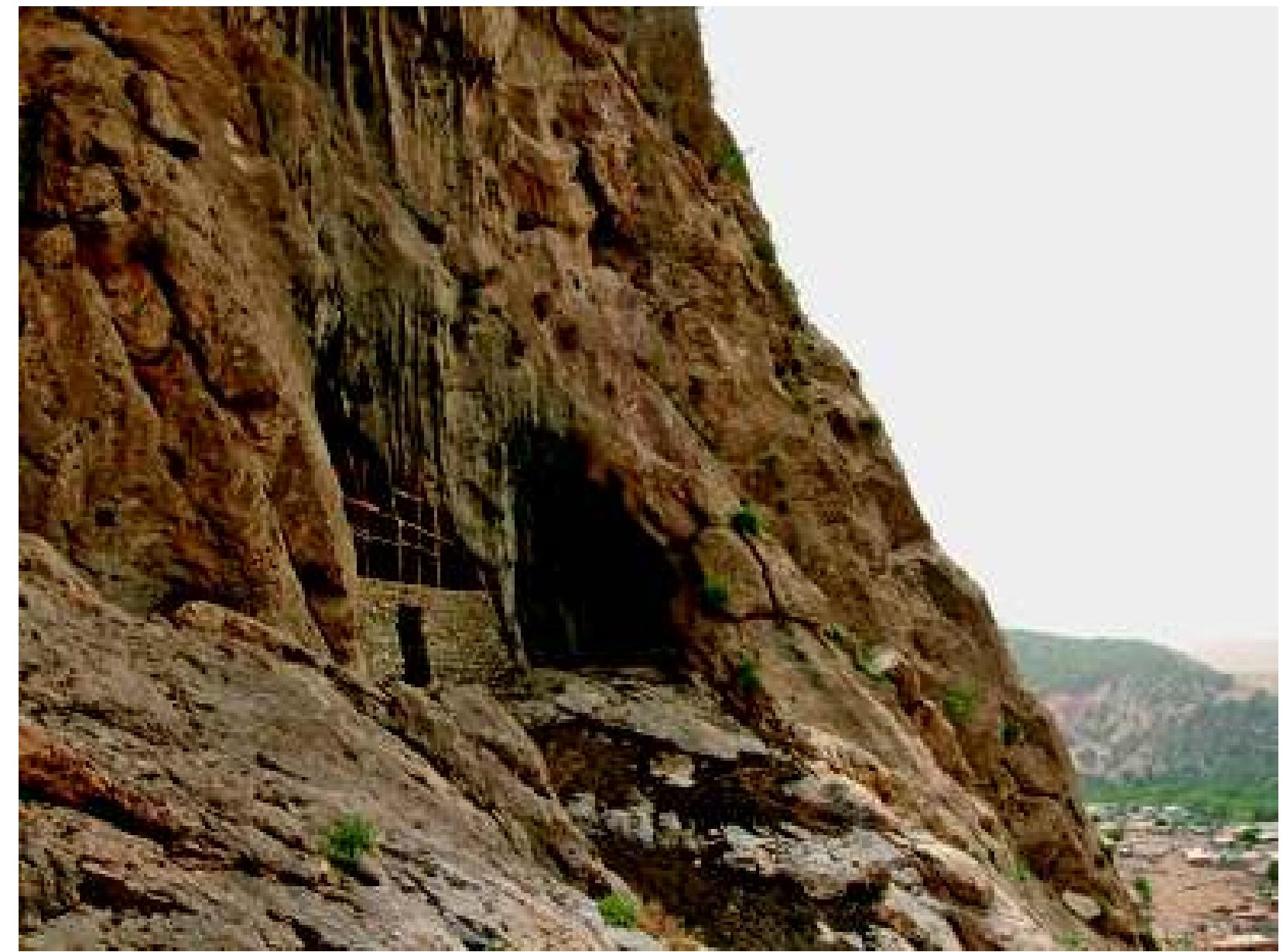 Fig. 31: Gunduk: Eastern side of main cave, with walled inner cave and niche; village in distance. Photograph: authors, June 2005 