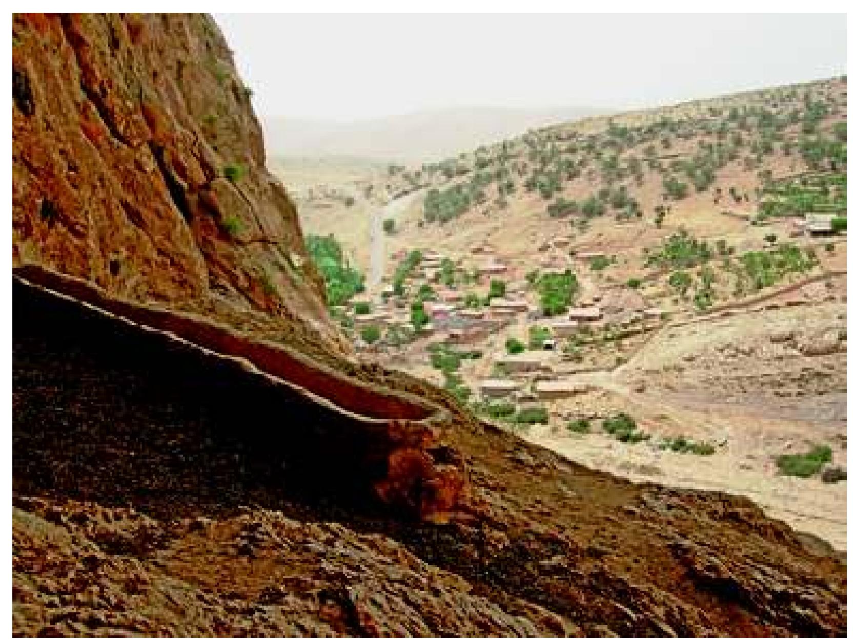 Fig. 33: Gunduk: Feeding trough for goats in cave, with village beyond. Photograph: authors, June 2009 