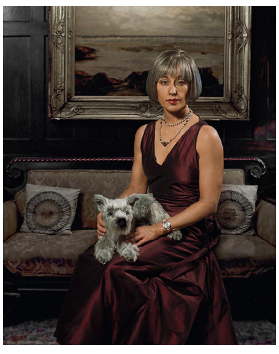 eee ee OEE eV  With this particular woman situated presumably in her own luxurious lounge room, we see again the enormous labour of femininity: her grey hair is perfectly modelled into a well-mannered bob — the default hairstyle of the middle-aged upper- and middle-class white woman, as age pronounces longer hair unsuitable, a fashion usually reserved for youth. Her eyes are enlarged and picked out by artfully applied eye shadow that creates large, recessed and well-defined, cat-like eyes — a feat of sculpture and painting that seems wasted on this everyday modelling task. 