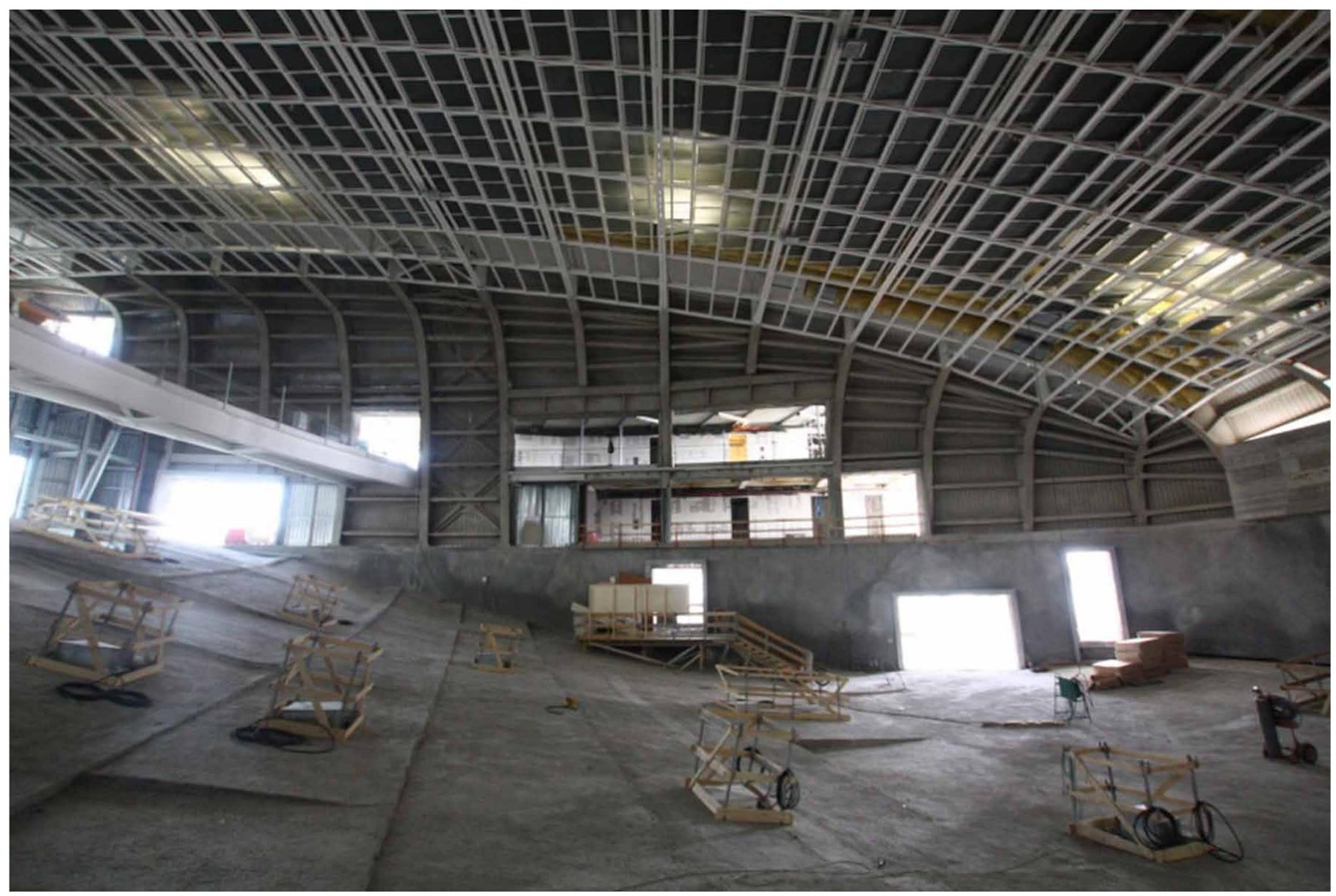 Figure I. Interior view of the main Auditorium of ,,the cloud“: Strucutral steel was already in place when the work started.  in complex wood furnishing. The purpose of the contract is a consultancy to help them in the geometry management and realization of the curved wooden envelopes of the main conference hall of the building, located inside the above mentioned freeform textile envelope of the “cloud”. At the beginning of the work of consultancy, in July 2013, the steel structure of the building is already erected, as shown in image 1.  in complex wood furnishing. The purpose of the contract is a consultancy to help them in the geometry 