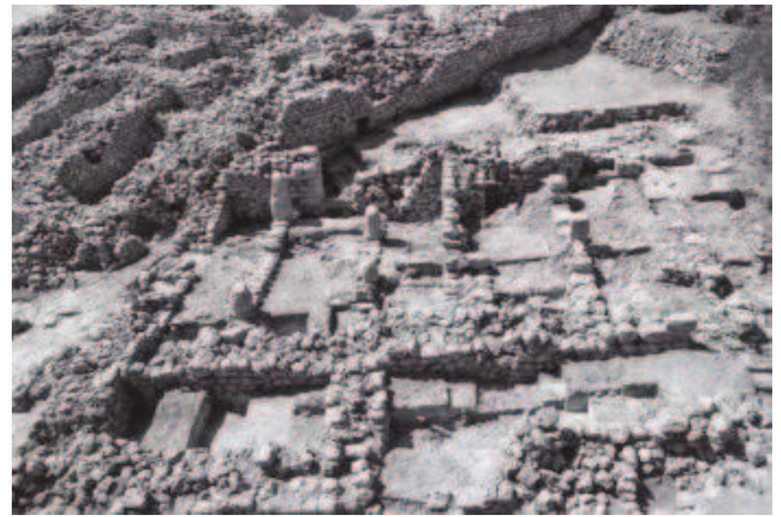 Figure 7. The Iron II building (in front), and the city wall (at back), from north; photographed by S. Amami.  Turning to the stratigraphic situation of the city wall versus the corner of the Iron II building, we notice that both structures adjoin one another (Figs. 5, 7-8). Batz (2017: 161, figs. 4, 13-14) believed that the Iron II building is later in date than the city wall. According to his interpretation, the building was built when the city wall — assumed to have been constructed eight hundred years earlier in MB II — was still standing in Iron II, to a considerable height with its face exposed. Furthermore, according to this scenario, the Iron II building was built without its south-eastern corner as the city wall extended at that time along the place where the edge of he building should have been situated. We can safely assume that the builders of the well- planned, solidly built Iron II building would have shifted its position by one meter or so to enable he construction of a proper corner. It follows, therefore, that the building is earlier than the city wall, and that in Iron II the building was constructed with a proper south-eastern corner. When he city wall was built at a later period, the corner of the earlier ruined building was dismantled.  n examining the published plan and photographs (Figs. 5, 7— 8), I observe no data which could preclude this reconstruction.  