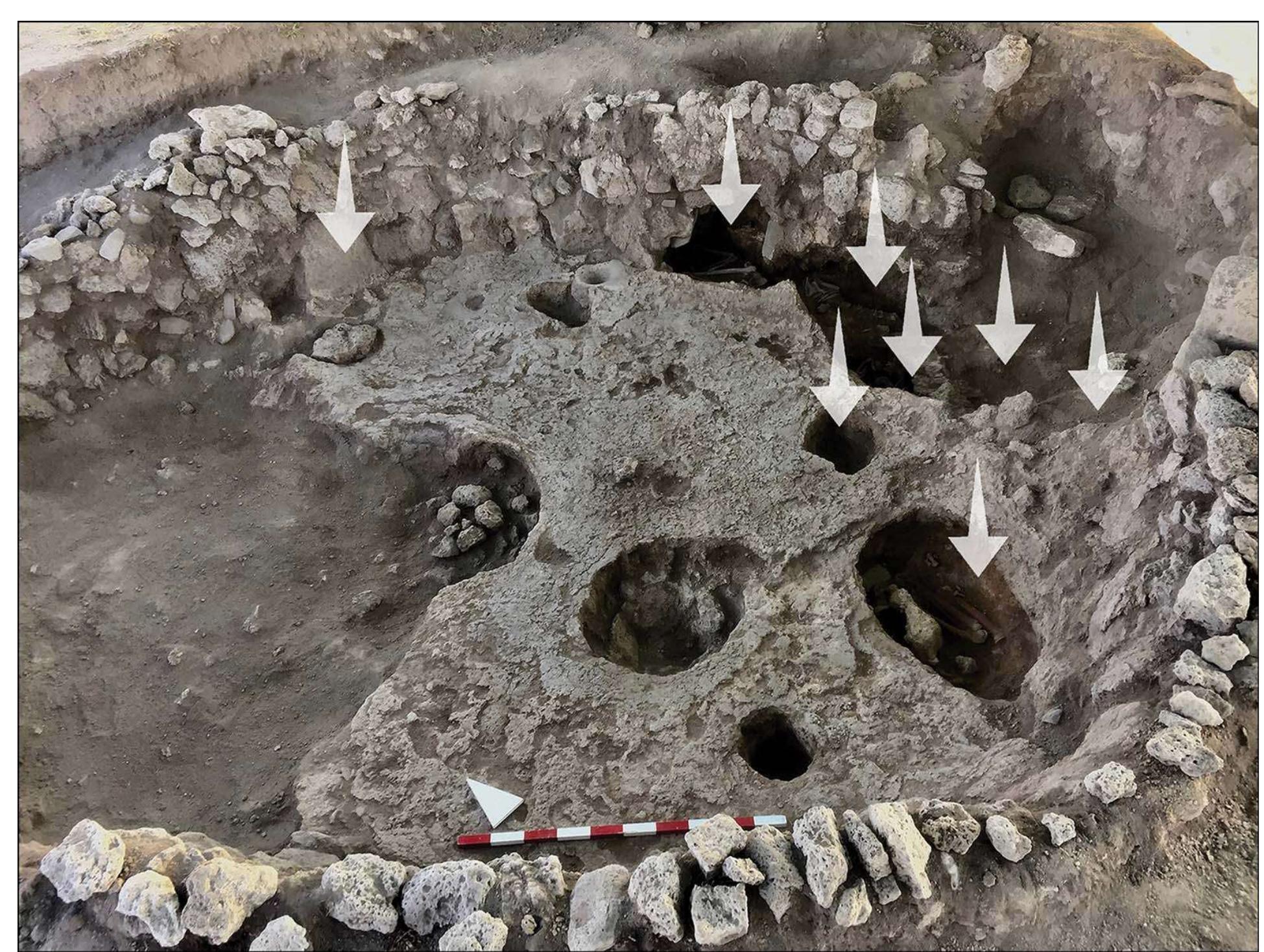 Figure 6. Burials in building 8, inserted in horizontal holes in walls (location shown with down arrows) (photograph by Balk: research project). 