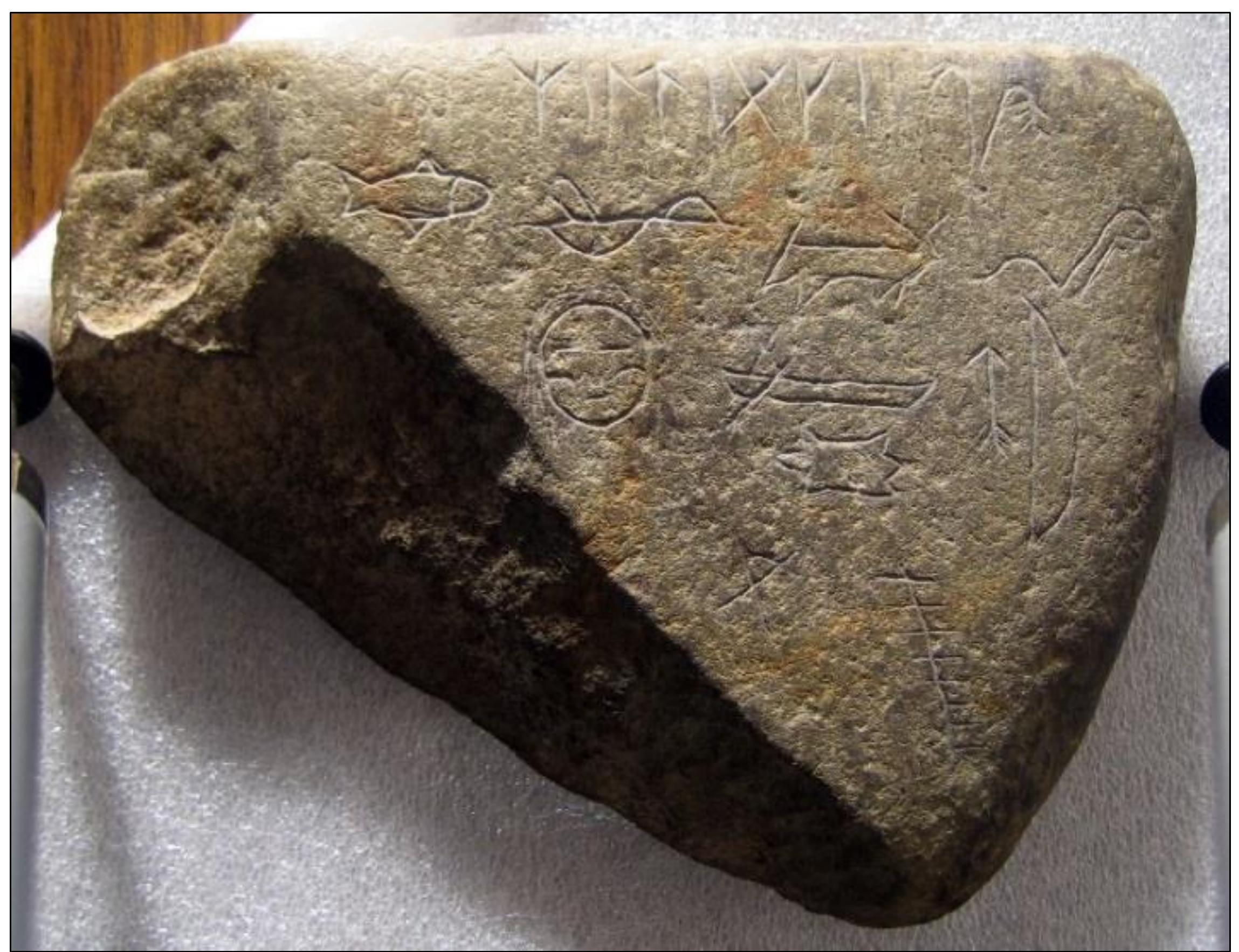 Figure 108. The reverse side of the Map Stone (SP1) artifact. Photo credit: Scott Wolter.  The Map Stone (SP1) artifact, crafted by Carver #1, was inscribed on two faces. The front side contained the schematic map and some inscribed runic words. The reverse side contained a series of pictographs and one inscribed runic word. 