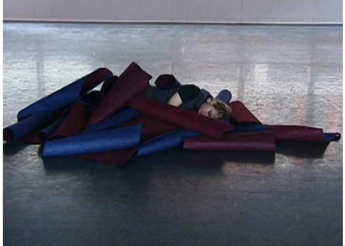 The ensemble referred to this image as the ‘nested child’ Thickly textured paper curls in folds around the body of the dancer. To the choreographer, the red and blue colours of the paper suggest both life-giving and life- draining qualities.  The following image illustrates the paper nest. During this week the choreographer introduced the idea of a lack of oxygen in the blood or body and the dancers were asked to consider what effect this would have on movement. 
