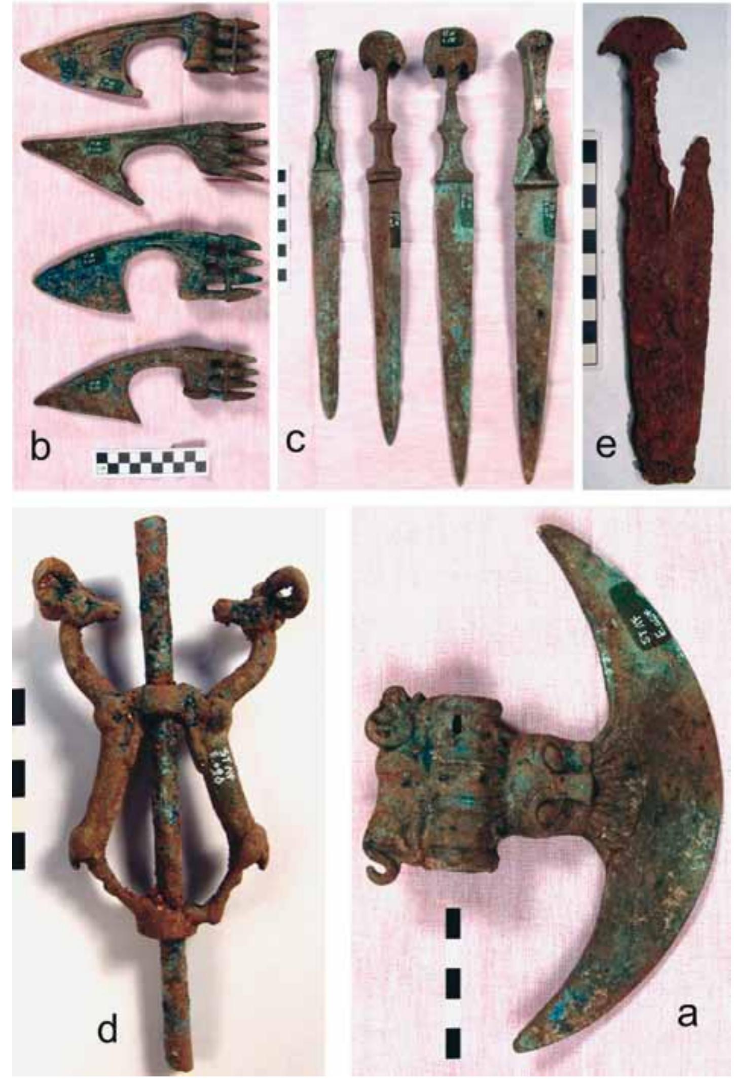 Pl. 4. Some artifacts from Sangtarashan: a. ST84 E.054, a decorated axe with a reclining animal on the shaft hol and a blade with lion faces at the base; b. ST84 E.065, 066, 067 and 068, four spike butted axe heads; c. ST84 E.005, 007, 008 and 093, bronze daggers; d. ST84 E.095: a bronze finial with its central tube in place; e. ST84 E.240, a broken iron sword. 