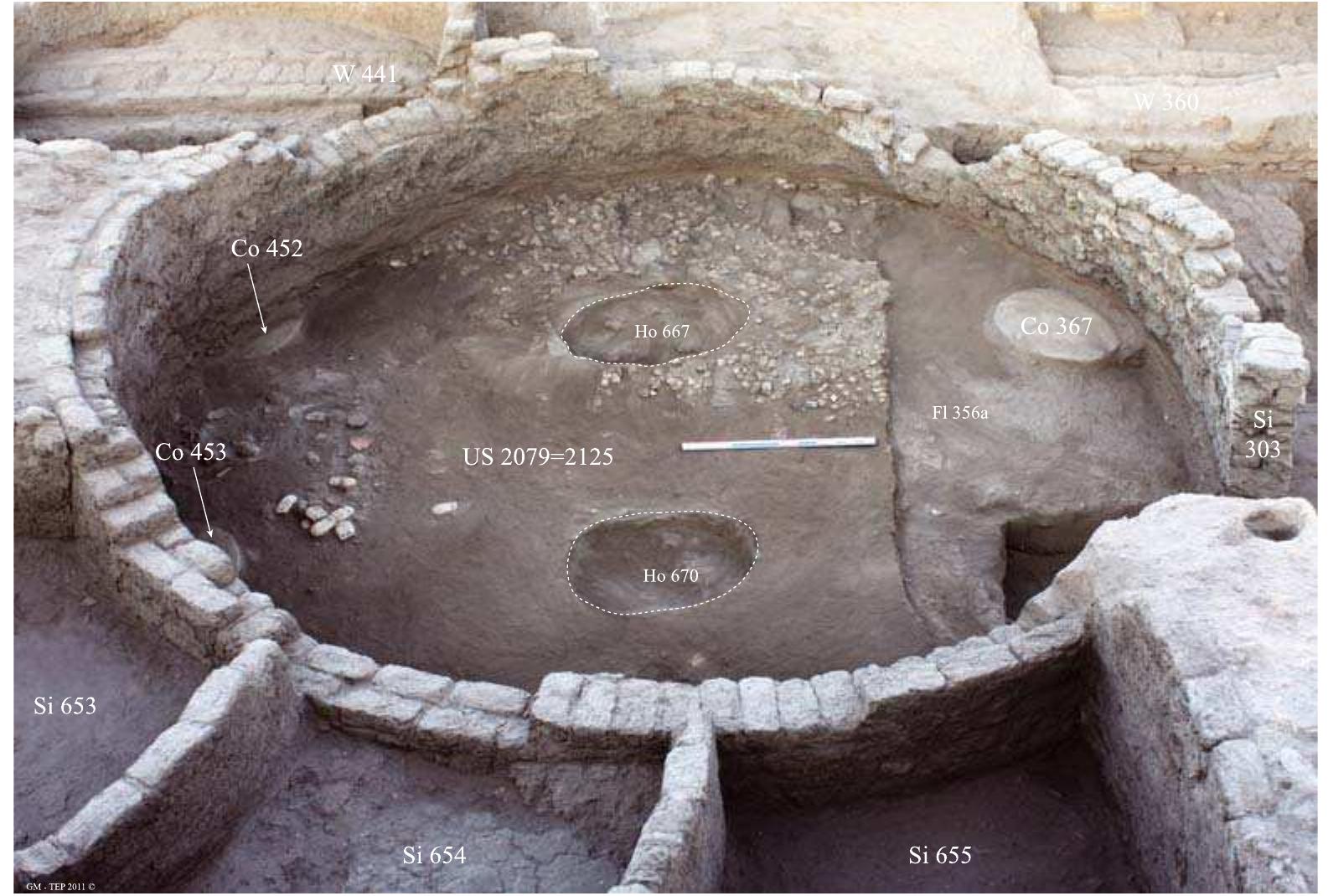 Fig. 8 West view of the final occupation layer (US 2079) in situ on the floor (Fl. 356a) of the southern columned hall showing the several concentrations of objects 