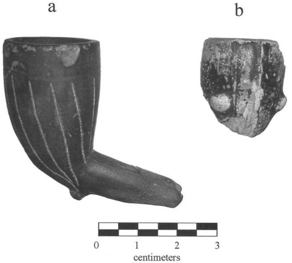 Figure 6. Locally modified European clay pipes from Njuinye. a, blackened pipe with vertical incisions on bowl; b, blackened pipe bowl with deep groove and knob appliqué. 