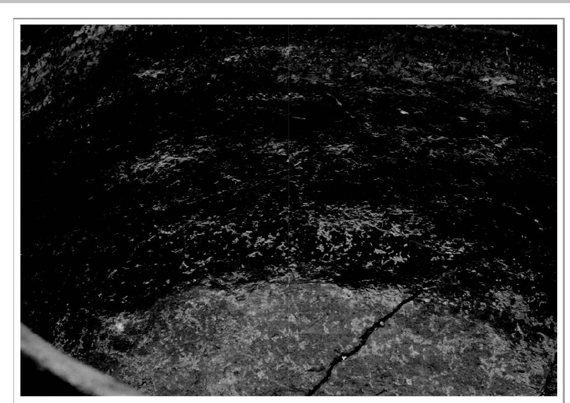 Figure 3. Detail from the inner part of vessel, regular undulation of the surface of a beaker. One of the rare imperfections of the surface treatments — evidence of the technique of coiling, horizontal facets and a burnt organic rest in the surface layer.
