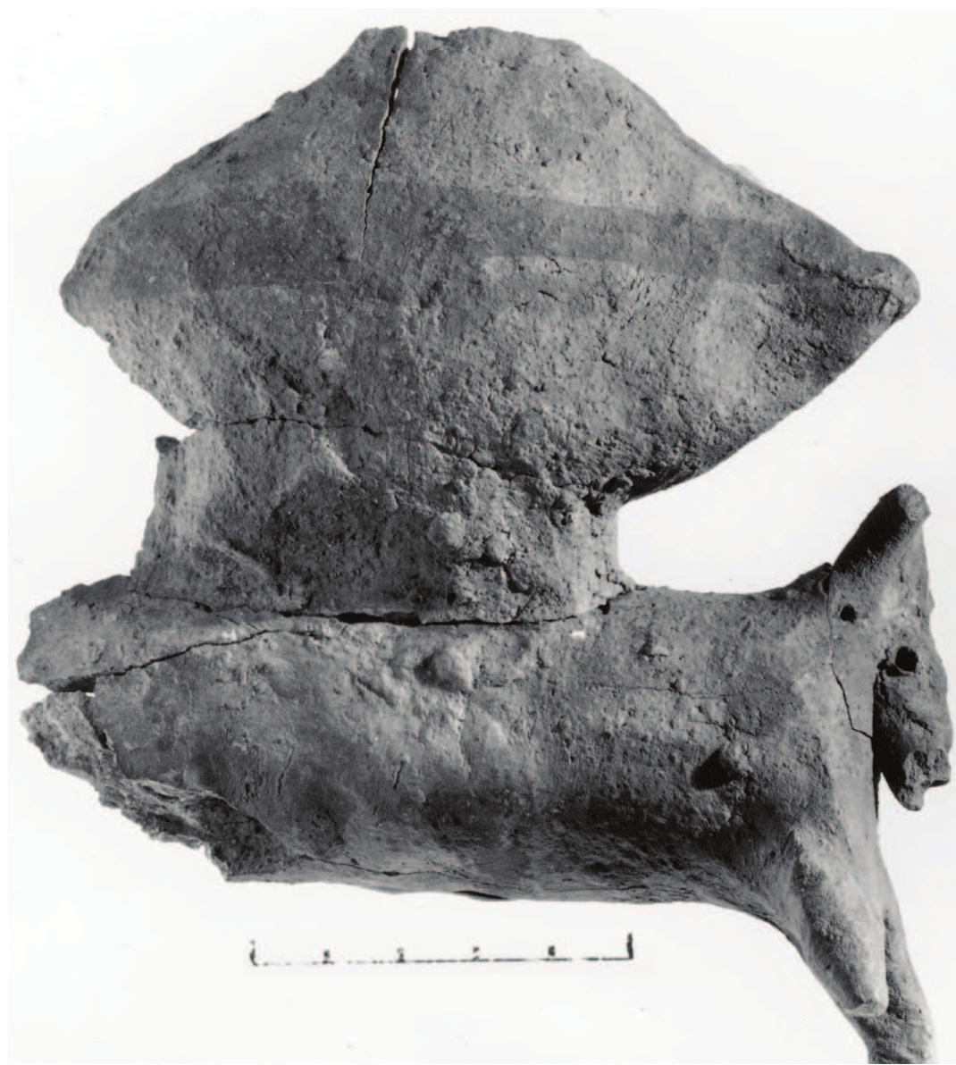 The temple’s location offers evidence for the cultic rituals per- formed at it. The main entrance faces the Ein Gedi spring and the second entrance is directed towards the Nahal David spring. It follows that the temple cult  Figure 11 (above). Figurine of a bull laden with two churns found in the altar. Photograph courtesy of the Israel Exploration Society, Jerusalem. Figure 12 (below). The circular installation in the courtyard of the temple, from south. Photograph by S. J. Schweig, courtesy of the Israel Exploration Society, Jerusalem.  caves. We concluded therefore that the temple served as a place for pilgrimage from close by as well as faraway regions, also for nomadic tribes.  One surprising observa- tion made at the time of the excavation was that no Ghas- sulian remains other than the temple have been discerned in the region of the Ein Gedi oasis, particularly not in the im- ——B.c.E. l mediate vicinity of the temple. Significant Chalcolithic-Ghassu- _not yie lian remains, however, were known in the Judean Desert and its —_ to pern  