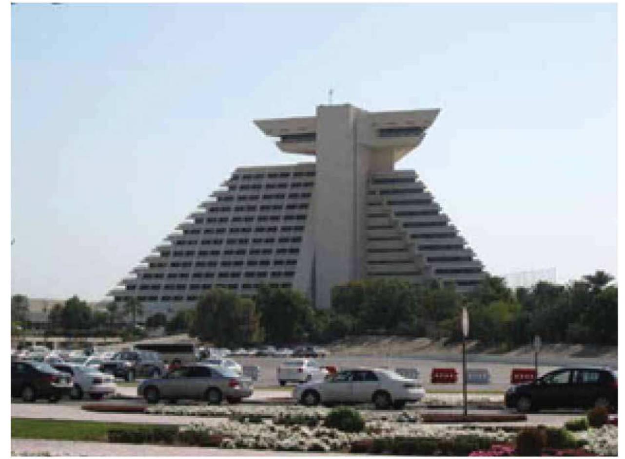 Figure 9. View of the Sheraton hotel in the West Bay built in 1983. —— heen ene ee ee a a Miraculously, Souk Wagif, along with a small number of districts and a few buildings, escaped damage. It was not until 2004 that a major rehabilitation of Souk Waqif was launched. While the strategy followed in reviving the area lacked authenticity, the souk has been given a new heart. After long years of decay it has become a major attraction for tourists and locals; it is bustling with life, day and night. Following this project another comprehensive reconstruction project has been undertaken in the Msheireb historic area, with the aim to rediscover the heart of Doha. Work started in 2008 and is still ongoing; it is due to finish in 2017. While the intention to revive the heart of Doha is important, its implementation led to the destruction of many historic