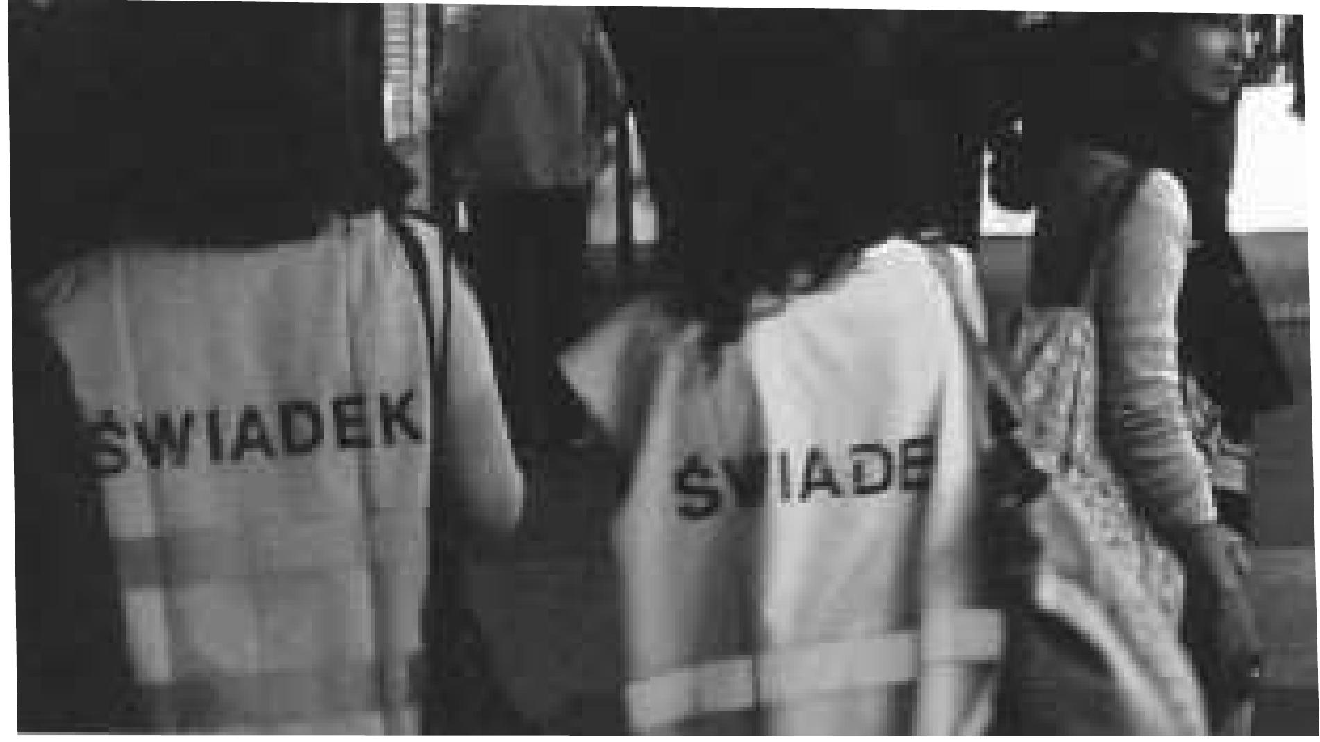 One of the characteristic features of the crime- prevention system at the Jarmark Europa open- air market and the Dworzec Wschodni train station in Warsaw was the visible presence of two-strong patrols in bright-yellow vests marked ‘Railway Guard, “Municipal Guard; or ‘Police. The situation gained a dramatic dimension following an incident in which an African small-time trader operating at the open-air market of the former Decennial Stadium was shot dead by the police.   As part of the action prepared by the AR with workshop participants, 20 ‘patrols’ operated in the ‘hazard zone of Dworzec Wschodni/Jarmark Europa dressed in bright-yellow vests marked by the following labels: Shepherd/Shepherdess, Ethicist, Poet, Pilgrim, Hussite, Witness, Tenor, Defender, Musician, Negotiator, Student, Model, Ascetic, Client, ‘Therapist, Patron, Observer, Cyclist, Participant, and Trader.  