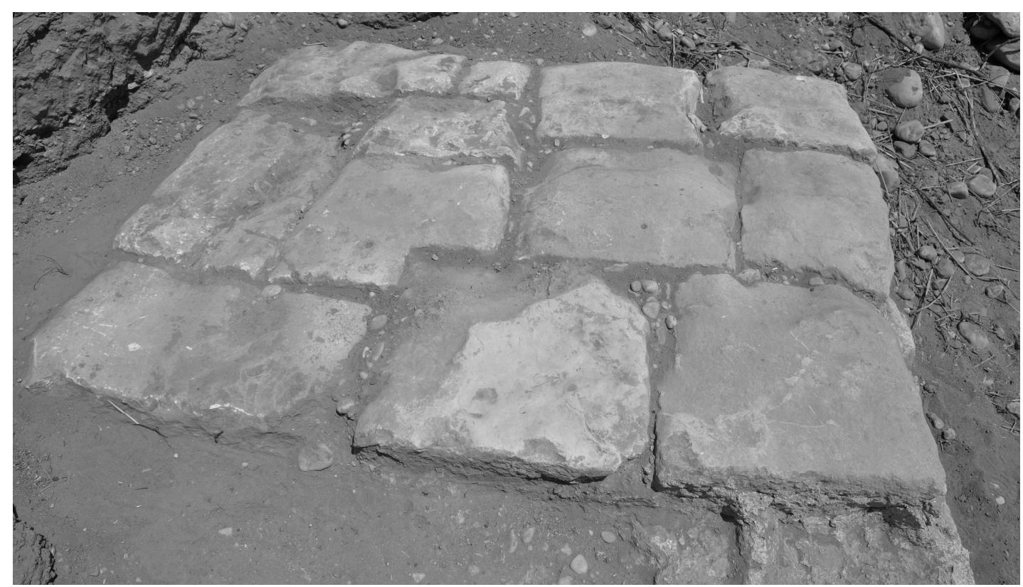 Fig. 7. Detail of quay paving slabs (© Italian Archaeological Mission to Assyria, University of Udine).  Though partially eroded, the northern end of the quay appears complete, whilst to the south it is still covered by a large quantity of river deposits, which it has not yet proved possible to remove. In the absence of excavation it is therefore impossi- ble to establish the overall length of the structure. 