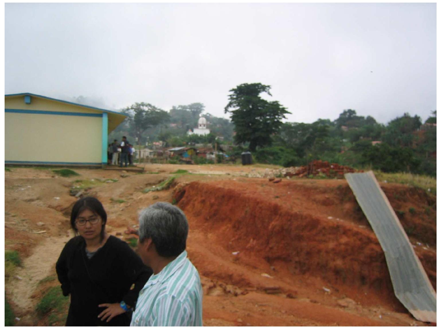 Ficure 7. Emiliana and Alfonso Merino on the sidelines, as the other teachers, standing outside the school, discuss among themselves. (Photo by Carlos Cruz) 