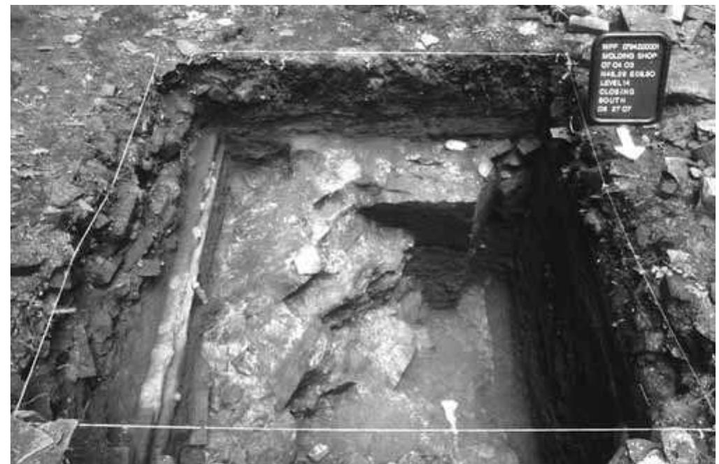 Figure 14. Furnace stack excavation photo. Note the iron rail (left) resting directly on top of the granite foundations. Photo by author.  The location of the pits in the gun foundry ruin is obvious; two large depressions partially filled with granite wall rubble lie within the foundation. The western pit was selected for excavation because it con- 