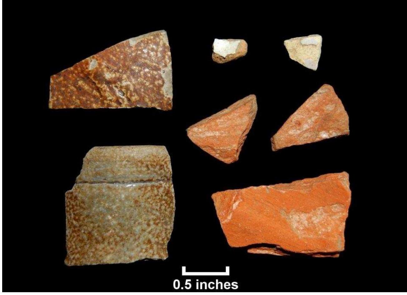 Figure 71. European ceramics from test units, Windy Knolls I; top row, possible Rhenish brown stoneware (Lot 235); tin-glazed earthenware; tin-glazed earthenware; middle row: Merida Micaceous IJ; Meridé Micaceous II ; bottom row, English brown stoneware rim (Lot 277), Merida Micaceous II (Lot 249).  All three possible Colonoware fragments from the Windy Knolls I site are small in size. One fragment is less than %4-inch in maximum length, possibly shell-tempered, and with a flat bottom and smooth angular sides. The second fragment is an unglazed micaceous red earthenware with a reduced gray core that may be from a vessel with a flat base. The sherd is 7/8-inch in diameter. The third possible colonoware fragment, recovered from a water-screened column sample, is a sand- and shell-tempered rim or base sherd. None of these fragments is fully convincing in large part because of their small size, but their forms suggest that Colonowares may in fact have been present at Windy Knolls I. 
