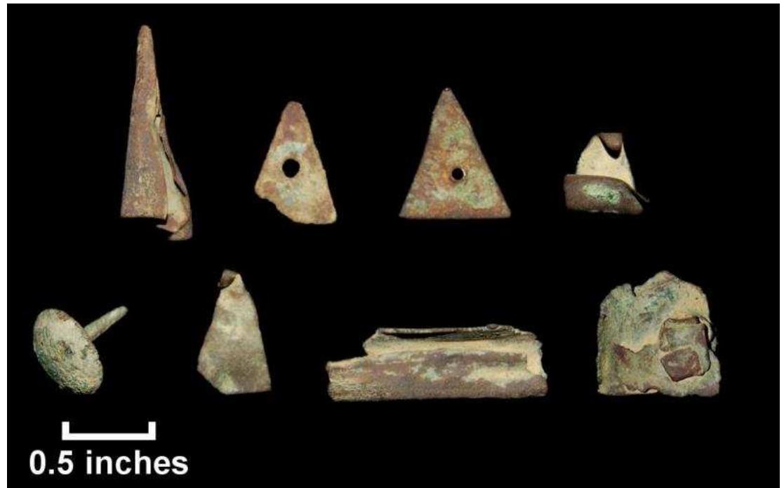 Figure 81. Copper alloy artifacts from test units, Windy Knolls I; top row, I-r: tinkling cone (Lot 237); perforated triangle fragment (Lot 258); perforated triangle (Lot 244); perforated triangle, bent (Lot 234); bottom row, I-r: tack (lot 255), triangle fragment, no perforation (Lot 254); scrap (Lot 258); rivet, possibly from a kettle (Lot 247).  Knolls I; top row, l-r: tinkling cone (Lot 237); perforated 