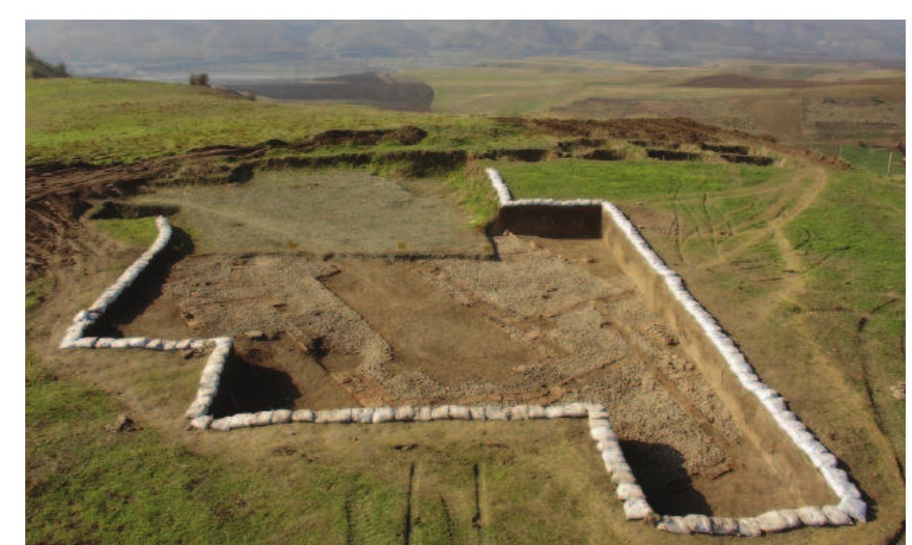 Fig. 3. View looking west across 2006 excavations, with soil covering the main 2005 excavations behind, and the Lesser Zab valley in the background. Courtesy of R. Heidari.  Plate I 