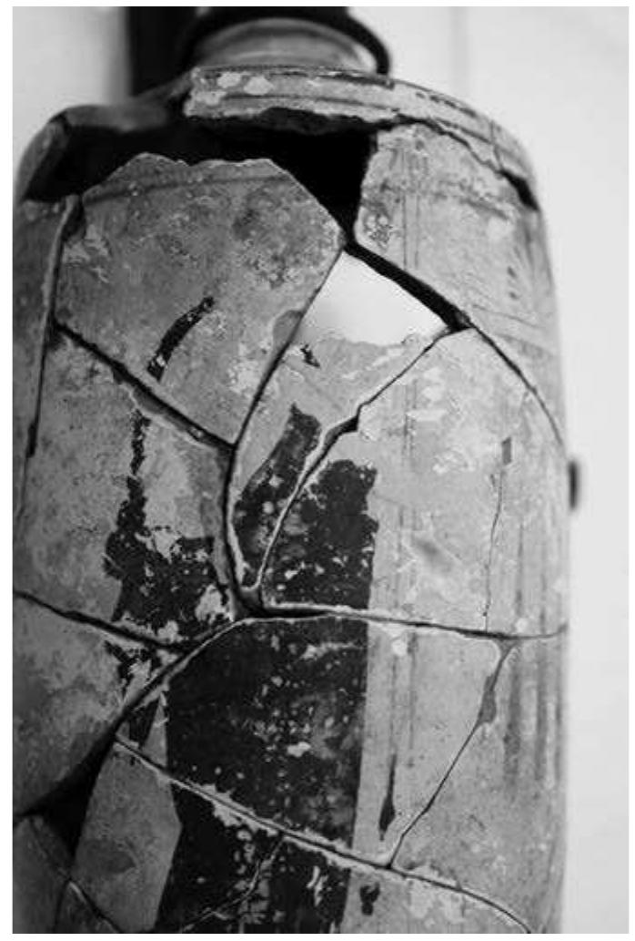 EXAMINATION OF A UNIQUE WHITE-GROUND LEKYTHOS  the long, slender staff immediately in front of him (fig. 2 and fig. 4). One is  not able to make o  ut the hand or the portion of the arm beneath the forearm  but the golden outline of the youth’s shoulder and upper arm are evident  and, therefore, al  ow for such a reconstruction. The appellation “youth” is  tentative, as the majority of the face of the figure is not extant (fig. 5). The  outline of the staff however, the outli hue. The youth we although no detai pose beneath the  f is drawn in the same gold dilute as the arm of the figure ne of the feet seem to be slightly darker—a golden-browr ars a himation, which is deep reddish-purple in colour, and s of the folds survive, one is able to discern a contrappostc heavy garment—the right knee is bent, shifting the weight  of the figure to the left foot, which is placed in front of the right, allowing the audience to understand motion toward the funerary monument at the centre of the scene (fig. 6).  As mentioned earlier the face of the vouth is missing. and. therefore 