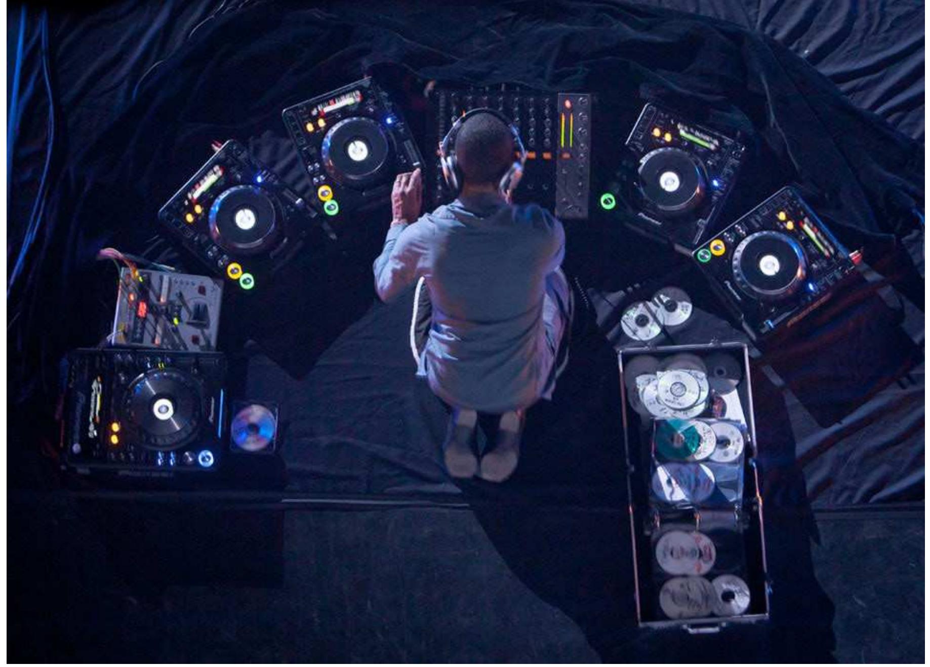 JEFF MILLS is crouched over his equipment: his fingers gracefully flying over the DJ mixer, silver headphones cocked on his head, his intense gaze taking in the five glowing Pioneer CD decks that surround him in a semi-circle. A heavy black cloth drapes the stage like a ceremonial shroud. Mills is a lone figure on stage, intense and focused, as if manning a solo soundship, the navigator of a relentless barrage of intergalactic techno (see fig. 1). The outer space symbolism of Mills’ multimedia composition is not accidental: the sights and sounds of Afrofuturism pervade the haunting, minimalist performance. A science fictional array of bleeps, squelches and synthesizers crack audibly like solar flares, punctuating the intensive polyrhythms and driving bass; behind Mills, a photograph of Earth’s moon fills the massive projection screen (see fig. 2 below).  FIGURE 1. JEFF MILLS AT MUTEK 2012, MONTREAL. PHOTO: MUTEK.ORG. 