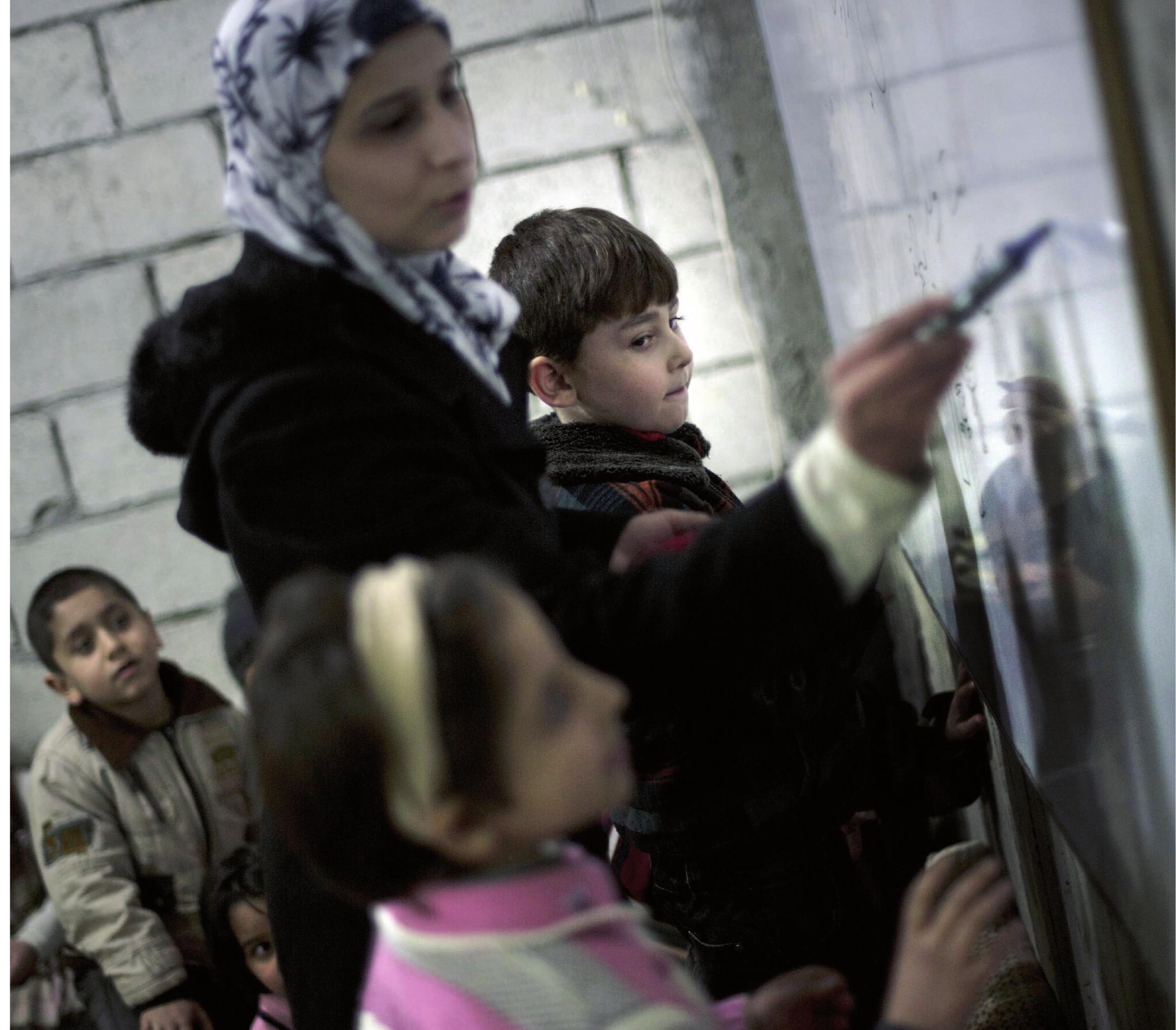 Children attending a makeshift school in the cellar of a building in the eastern town of Deir Ezzor in 2013. After IS took power in July 2014, it has been increasingly difficult for women to take on public roles, like teaching. Photo: TT/AFP/Zac Baillie 