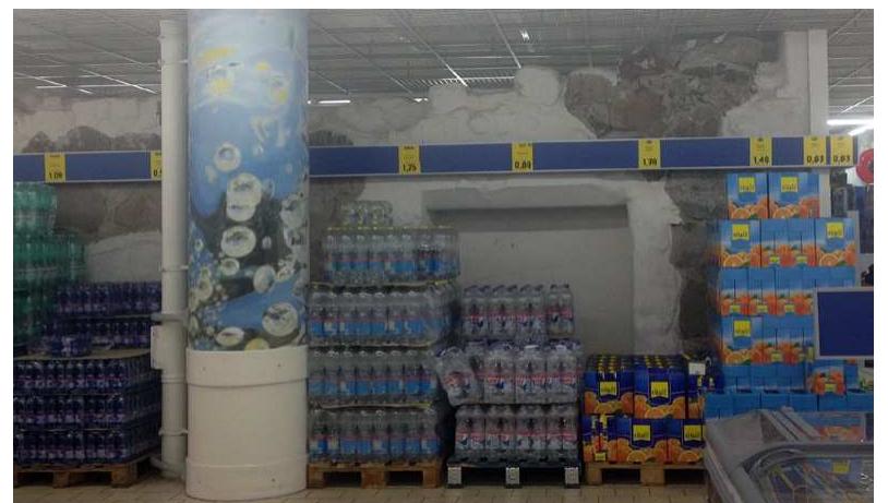 Figure 6 — Past and present in harmony?Archaeolog- ical remains unearthed in the 1980s are roofed within a grocery store today. Probably, most of the customers are not aware of the history of the place and do not pay any attention to the remains surrounded by the mer- chandise. (Copyright: The author) 