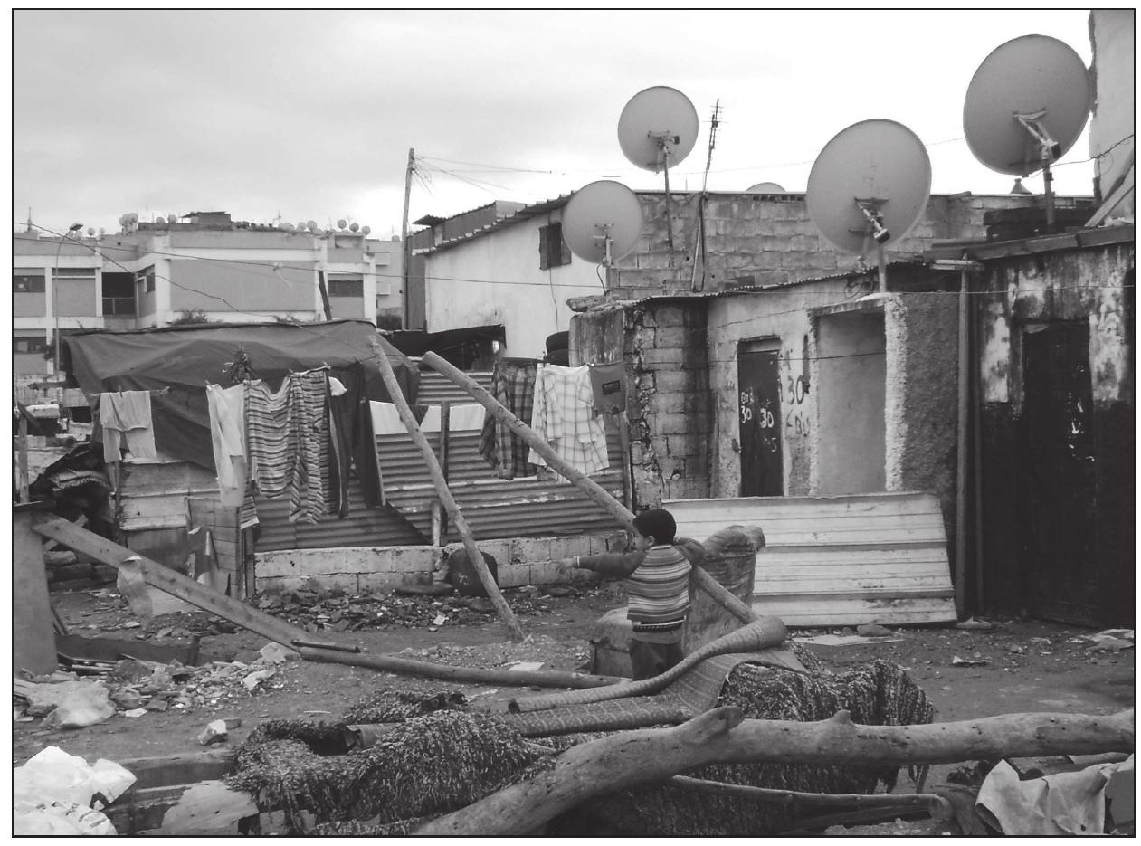 » A forgotten Moroccan boy plays in the slums of Carriéres Centrales.  We asked Khalid if he was satisfied with his decision to settle in Casablanca or whether he regretted quitting the countryside. We also asked him to compare his situa- tion in Ben Ahmed with the way he currently lives in Casablanca. Khalid told us that he regrets moving to Casablanca and that if he did not have five children, he would have returned to his parents in the countryside long ago. However, as there are no schools and other services in Ben Ahmed, he thinks that it is better for the future of his children to stay in Casablanca. He is clear though, that if he had known Casablanca in 1975 like he knows it today he would never have come, as the metropolis can not offer him the job and living conditions he had once dreamed of. He would have stayed with his parents in the countryside. That said, the farm they had lived in there was worse than the over- crowded slum he inhabits today and it had no electricity and running water. In general, however, Khalid believes that he had lived a better life in the countryside than he does in Dar el Beida. ‘Nevertheless, in the present situation’, he repeated again, ‘it is better to stay just in Casa’. He does not want to go anywhere else anymore. The unsuccessful adventure in Saudi Arabia erased his hopes for improving his standard of living any- where else in the world. He certainly does not want to go anywhere where he does not have family anymore; and all his relatives live either in Ben Ahmed or in Casablanca. 