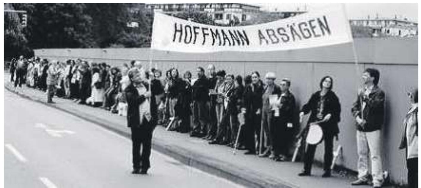 Figure 14, Protest against the reconstruction of the Palace, will be placed  Harrmann (2006, pp. 34-48) describes the situation of the Palace as “a wolf in sheep’s clothing”, and emphasizes that emotionally the demolition of the Palace had never been accepted. On the other hand, the reconstruction project was also protested when the re-construction process began in 2005 (Figure 14). 