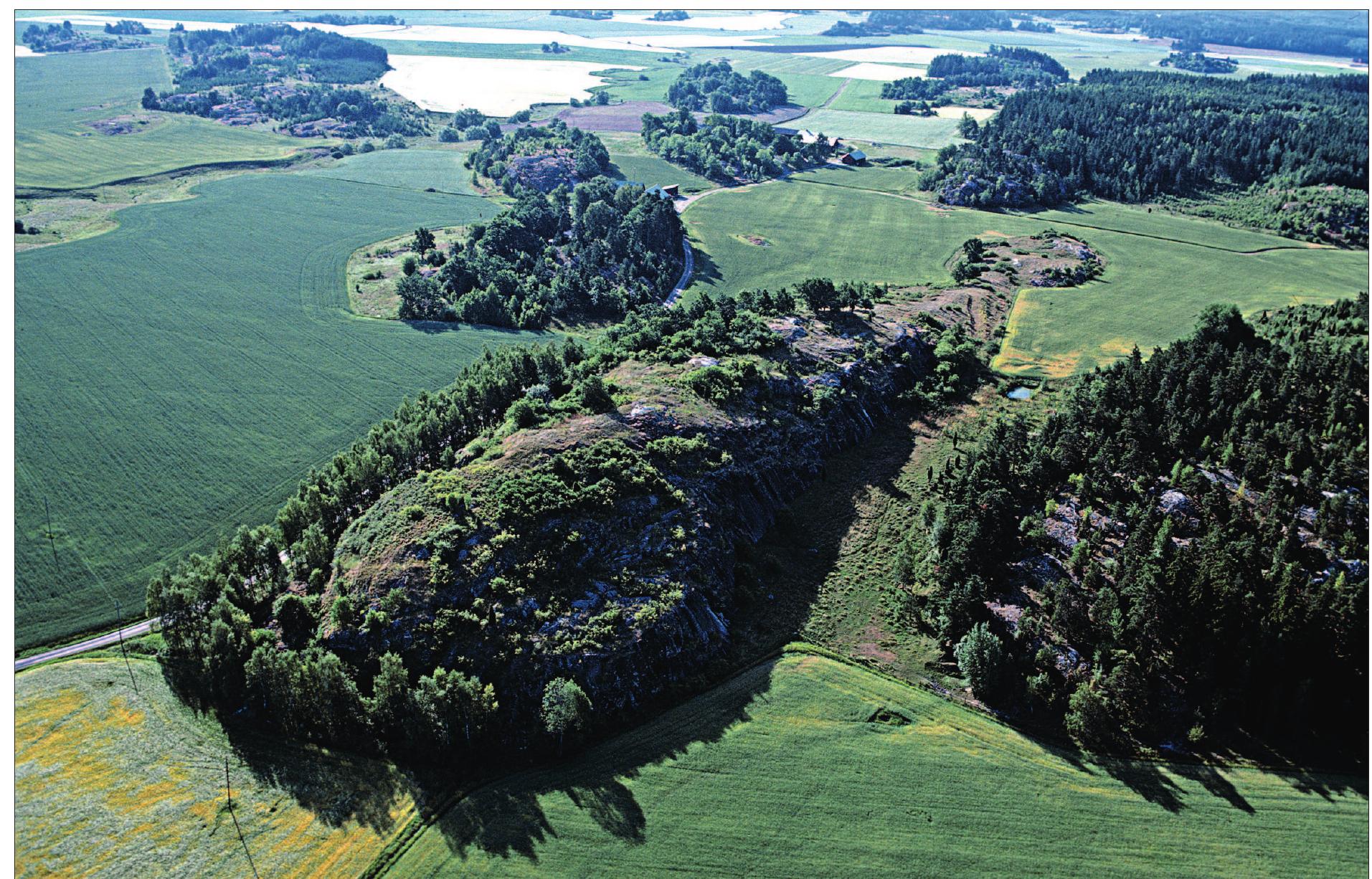 Figure 14. Few monuments can be said to represent the typical Swedish hilltop sites from the Migration period in such excel- lence as do Boberget (lit. ‘the settled mountain’) in Ostra Stenby parish on the Vikbolandet-peninsula, prov. of Ostergétland. The sharply accented hill witch features dense settlement deposits all over the main plateau lie surrounded by low, clayish soils which were mainly used as pastures and meadows during the 5th and 6th centuries A.D. The site was partly excavated between 1906 and 1909. This residence of the regional elite was singled out and defended by a short, but high wall across the ridge which can be seen to the back of the image. Photo: Pal-Nils Nilsson, courtesy RAA, pnn02063. 