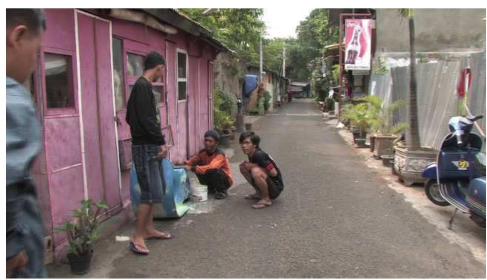 FIGURE 14. Film still of Jalan Sentul 2011.  The living conditions of Pak Aseni and Ibu Jamila seem dire, comparable perhaps to those found in Jakar- a’s_ notorious slums (e.g., Jembatan Besi or Penjaringan). Like slums, however, these images com- municate a complex of creative, emotive, and moral aspects of survival as much as a sense of real suffering see, e.g., Brown 2011). What stands out is the way in which Aseni and Jamila have tried to build and furnish a “proper” house, including the improvised kitchen and he family memorabilia on the wall. While they may be victims of gentrification or top-down policies of replac-  