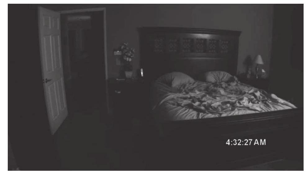 Figure 9. Paranormal Activity (Paramount, 2012): The action takes place in the dark background, directing our gaze to a vanishing point and leaving the room empty of figures.  a S (  sxpands the frame’s territory by bringing the background into relevance.*°  The found-footage horror film offers also more radical ways of decentering our zaze and expanding the frame. Paranormal Activity 4 forces us to stare at an empty bed- room through the eyes of a laptop camera, which in this case is also Ben’s eyes, when us girlfriend Alex leaves the computer chat—and the frame—for forty-eight seconds. The laptop camera, which rests on a bed, frames the borders of the mattress, a pillow, 1 cushion, a toy shelf, and an open door. Ben gets nervous and starts calling Alex’s aame from off-screen—to be precise, from behind the computer camera. The absence of visible characters and the immobility of the frame build up suspense, until we see he silhouette of a child run past the door, and then, after a few more seconds, we see Alex jump back, startling Ben—and probably the audience (Figures 10 and 11). Where n the attack on Katie our gaze may not have been able to focus on the main action but was still directed at a specific corner, in this scene from Paranormal Activity 4 we are left ‘0 our Own devices as we are invited to scan the whole of the image for a sign of the -xtraordinary (or do the opposite: focus on a specific corner so as to avoid the signs of 1 monstrous presence). Here it is not only the background that acquires relevance but ilso every single corner of the image. The frame’s territory is further expanded.  Although I have treated the frame’s elasticity and permeability from an optical per-  ee) a Te ee oe a : i i a ee : a) en ha, FT ime | 