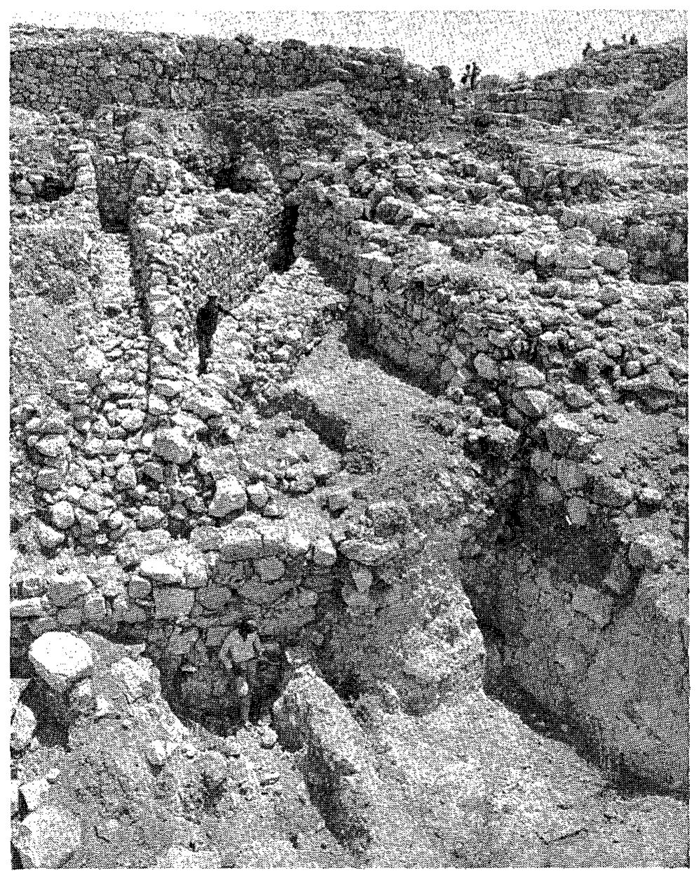 Fig. 36. The outer revetment wall and the Levels IV—III drains to the north of the city gate complex which is seen at right, from west. 
