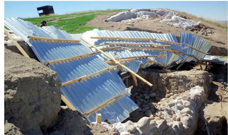 Figure 4: View of the shelter over Operation A after being lifted for the first time and damaged by wind.  Figure 3: View of the structure of the shelter over Operation B. On the right a pillar without concrete base can be seen. 